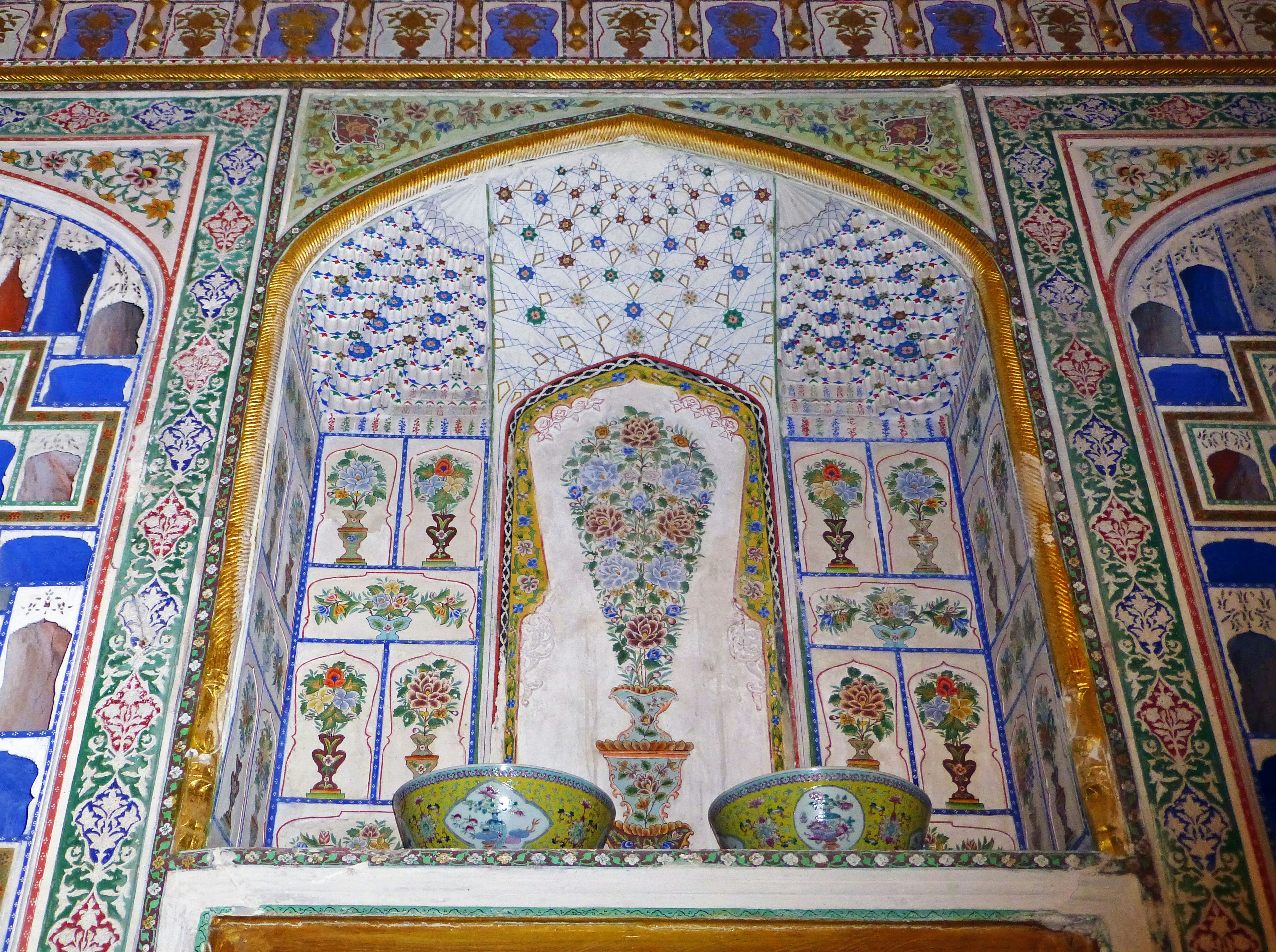 Beautifully decorated wall featuring an arch niche with vibrant floral motifs