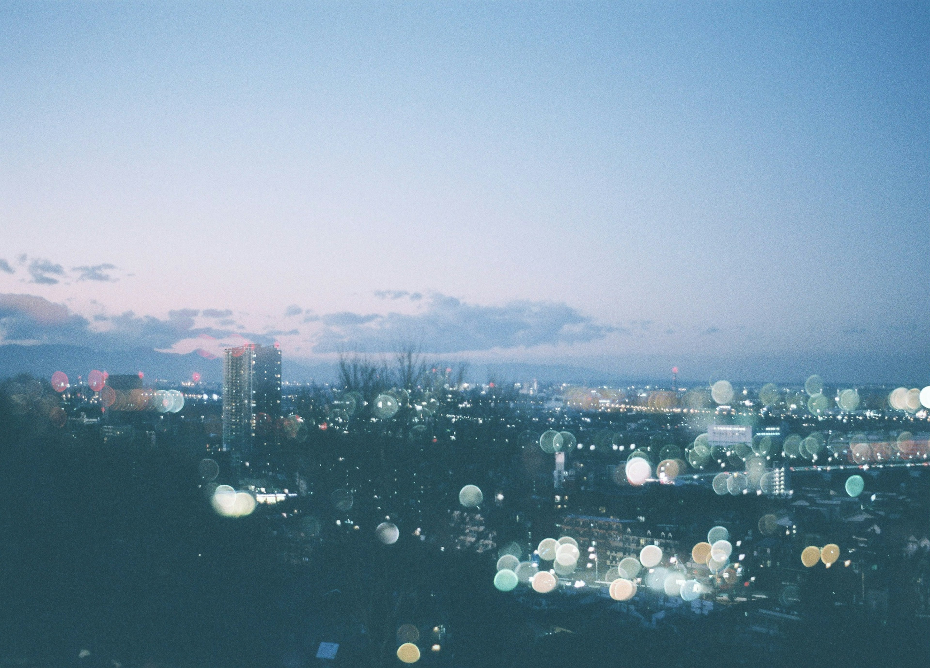 Blurred city lights against a gradient evening sky