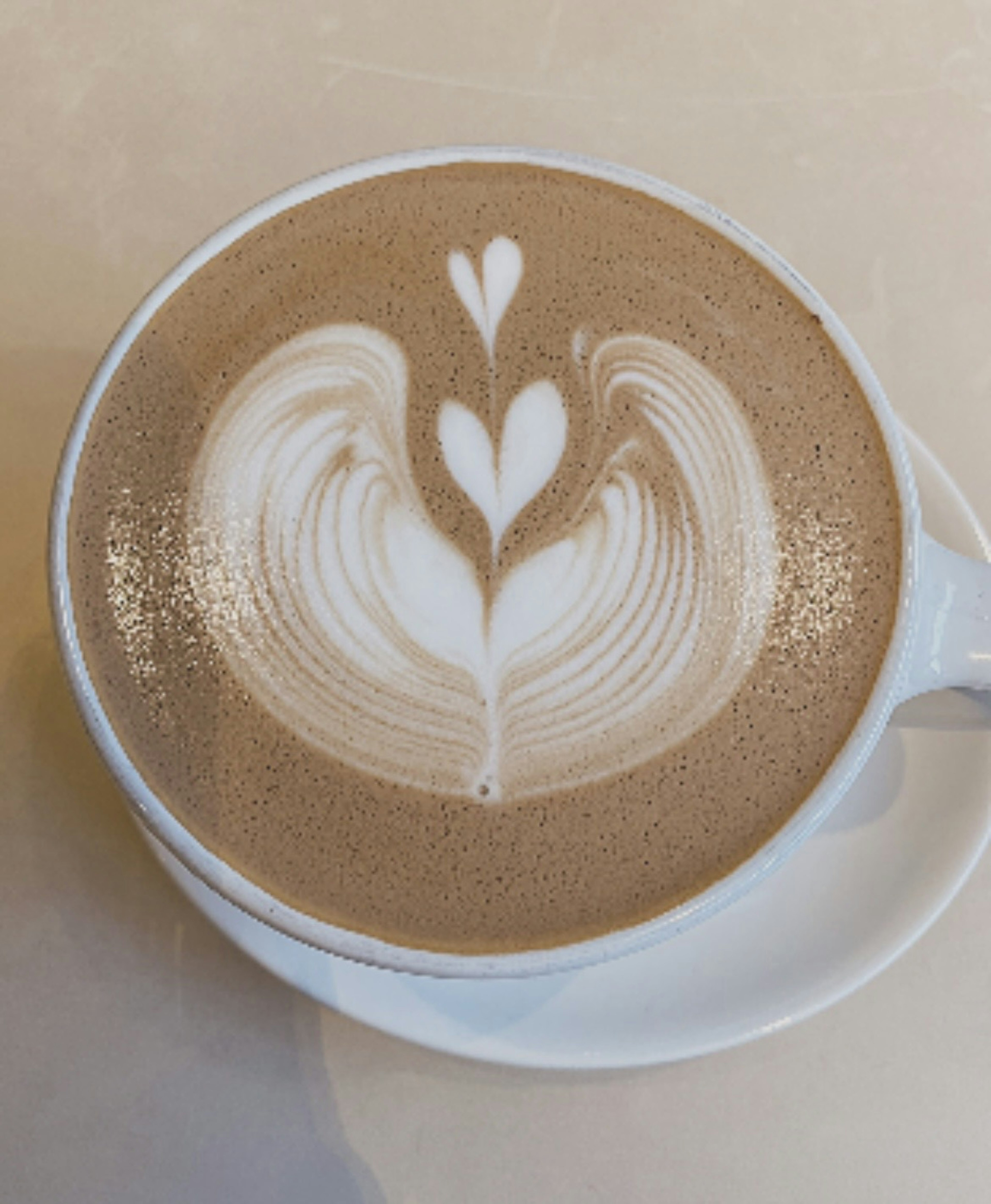 Bellissima arte del caffè con cuori sulla superficie del caffè in una tazza bianca