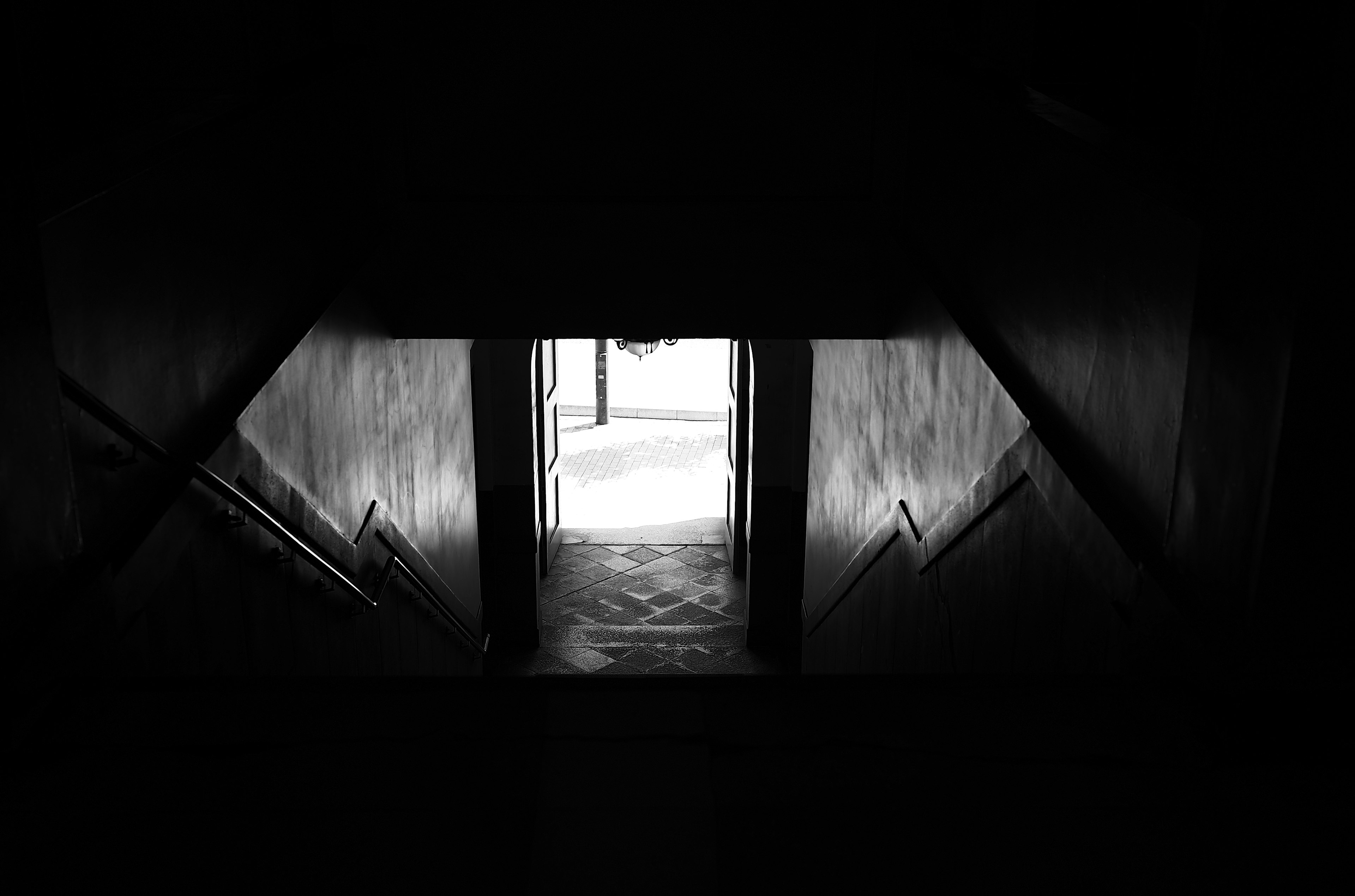 Dark staircase leading to a bright doorway