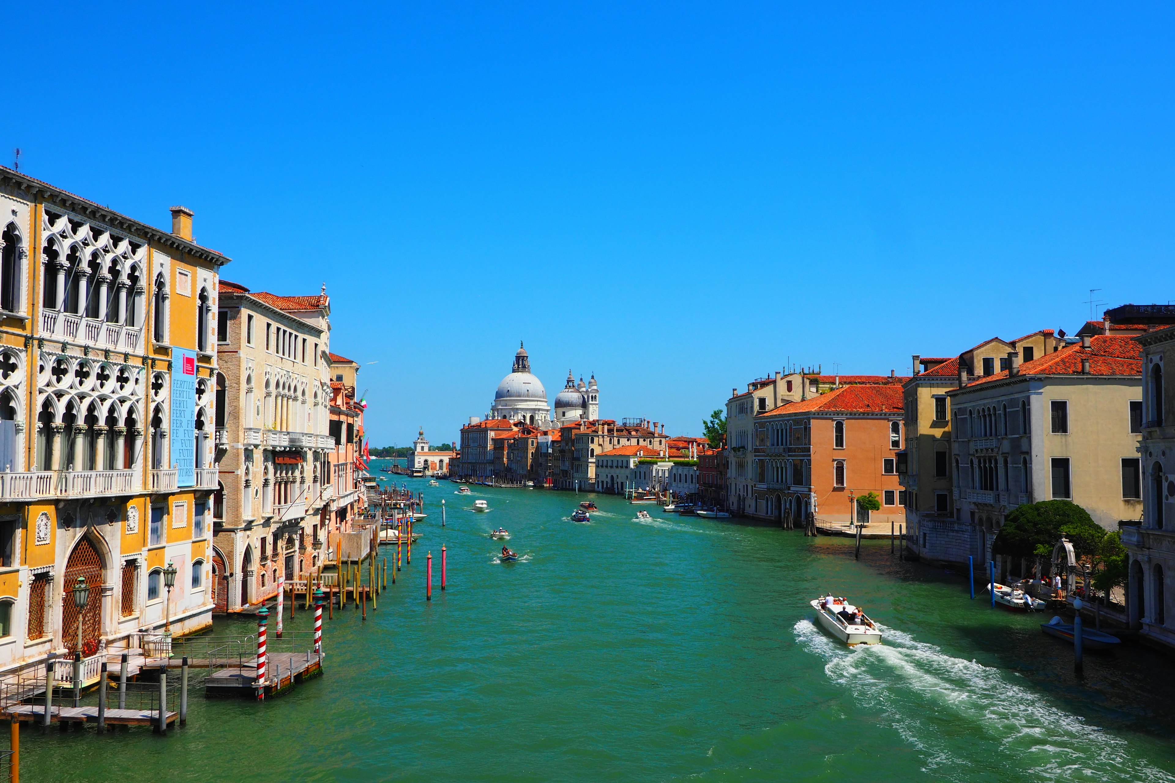 Venezianischer Kanal mit historischen Gebäuden unter blauem Himmel