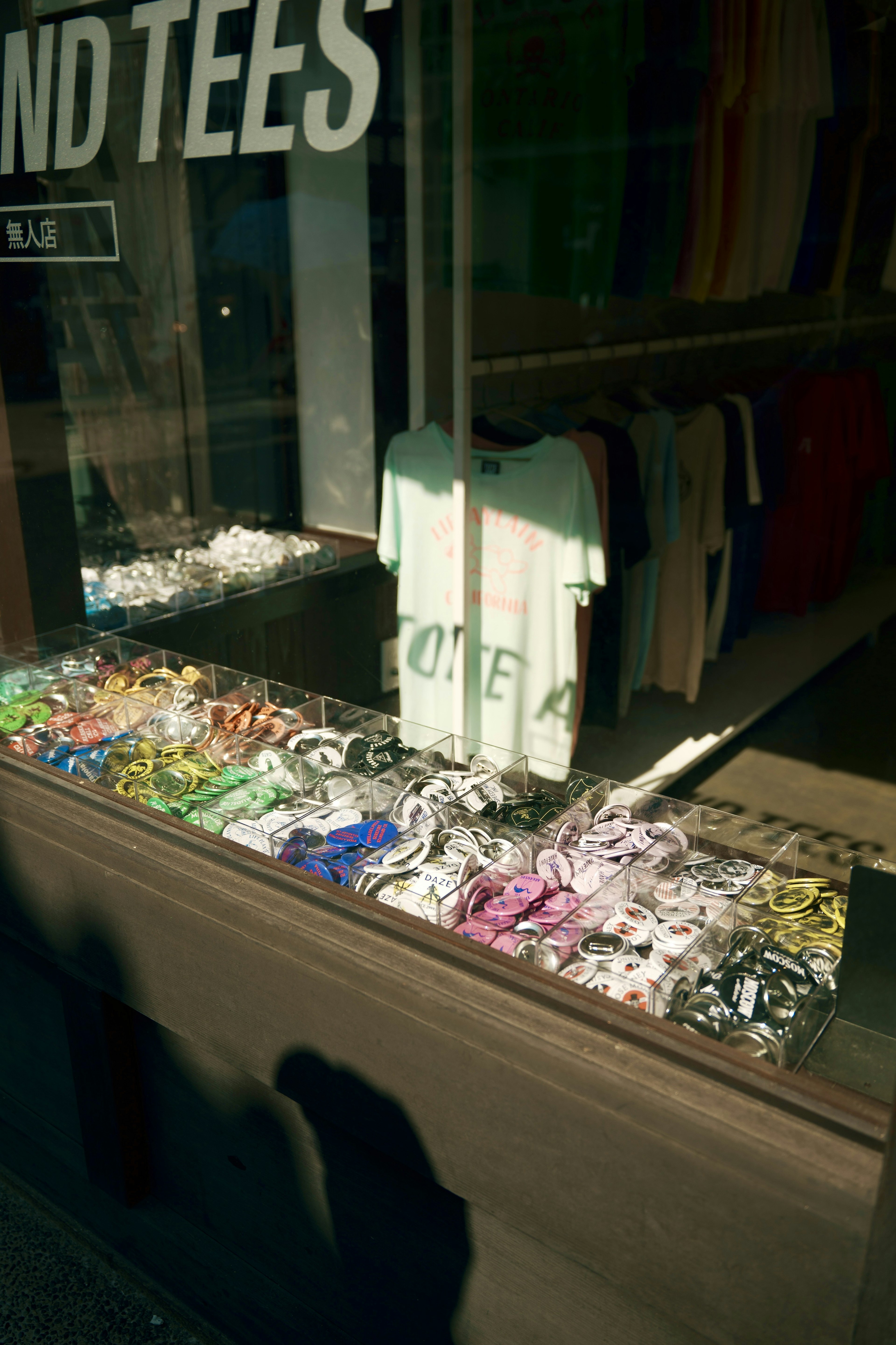 Colorful t-shirts and accessories displayed in a shop window