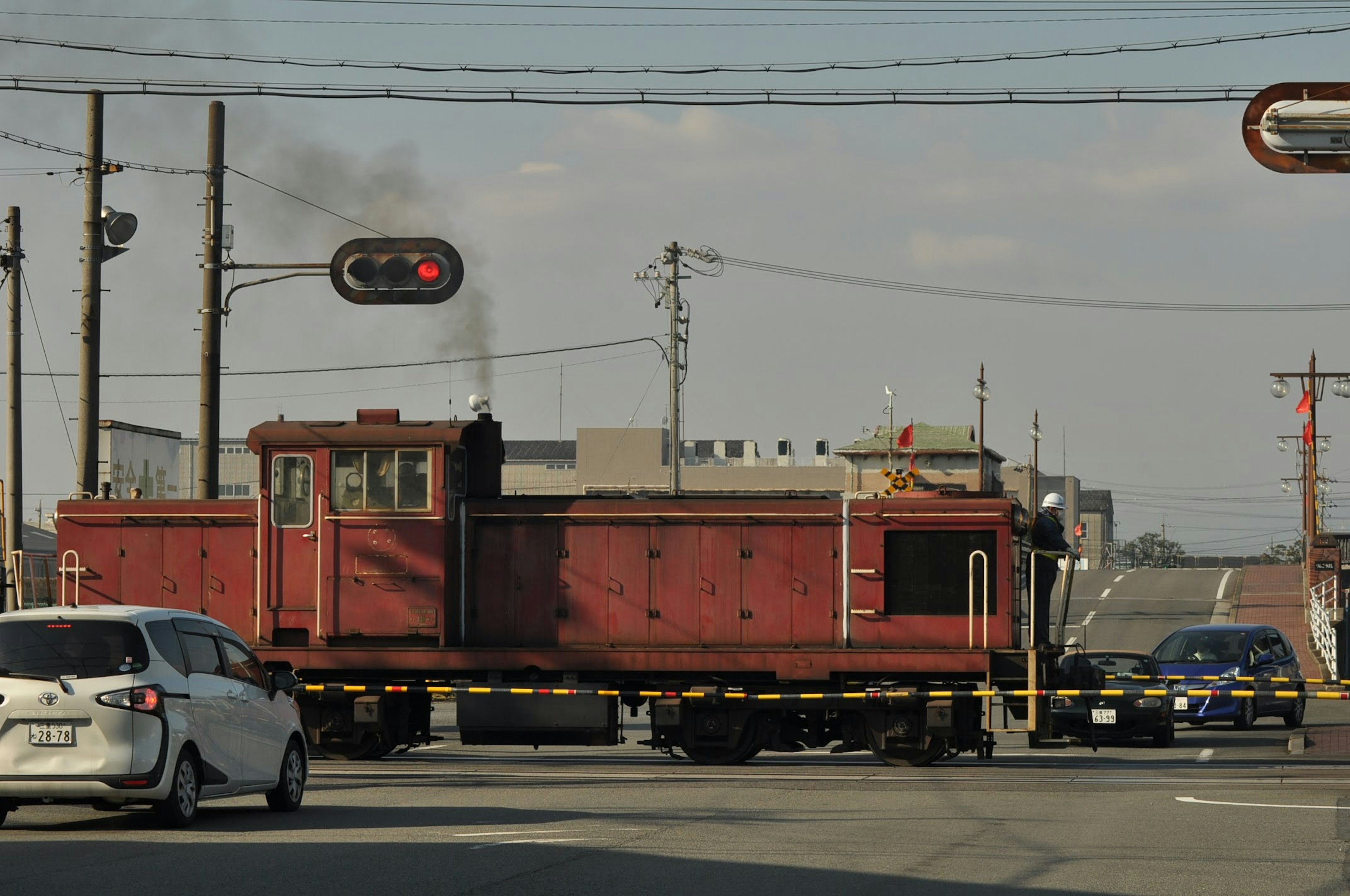 Locomotora roja cruzando una intersección con semáforos