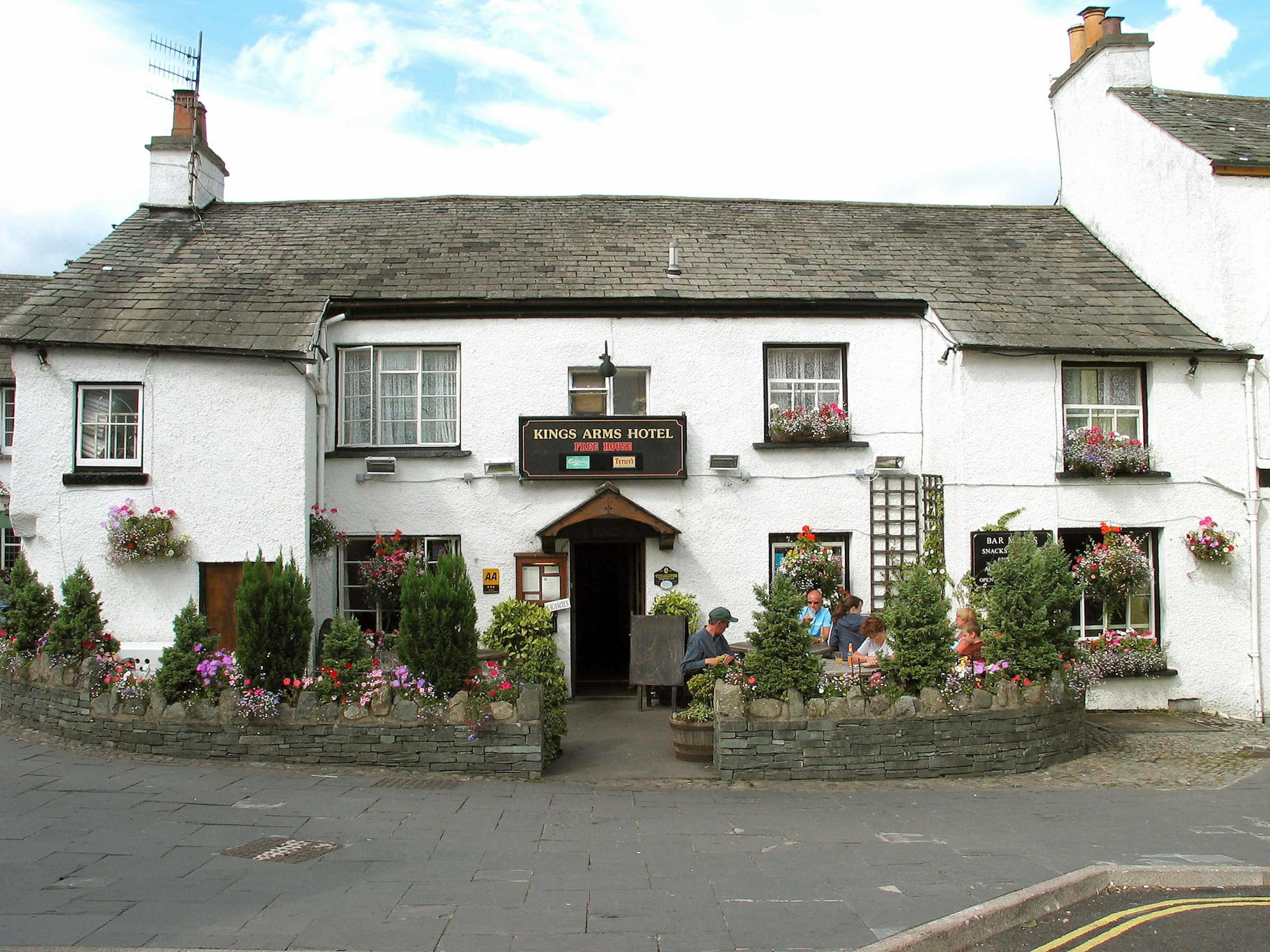 Traditionelles Pub mit weißen Wänden und blumenverzierten Fenstern