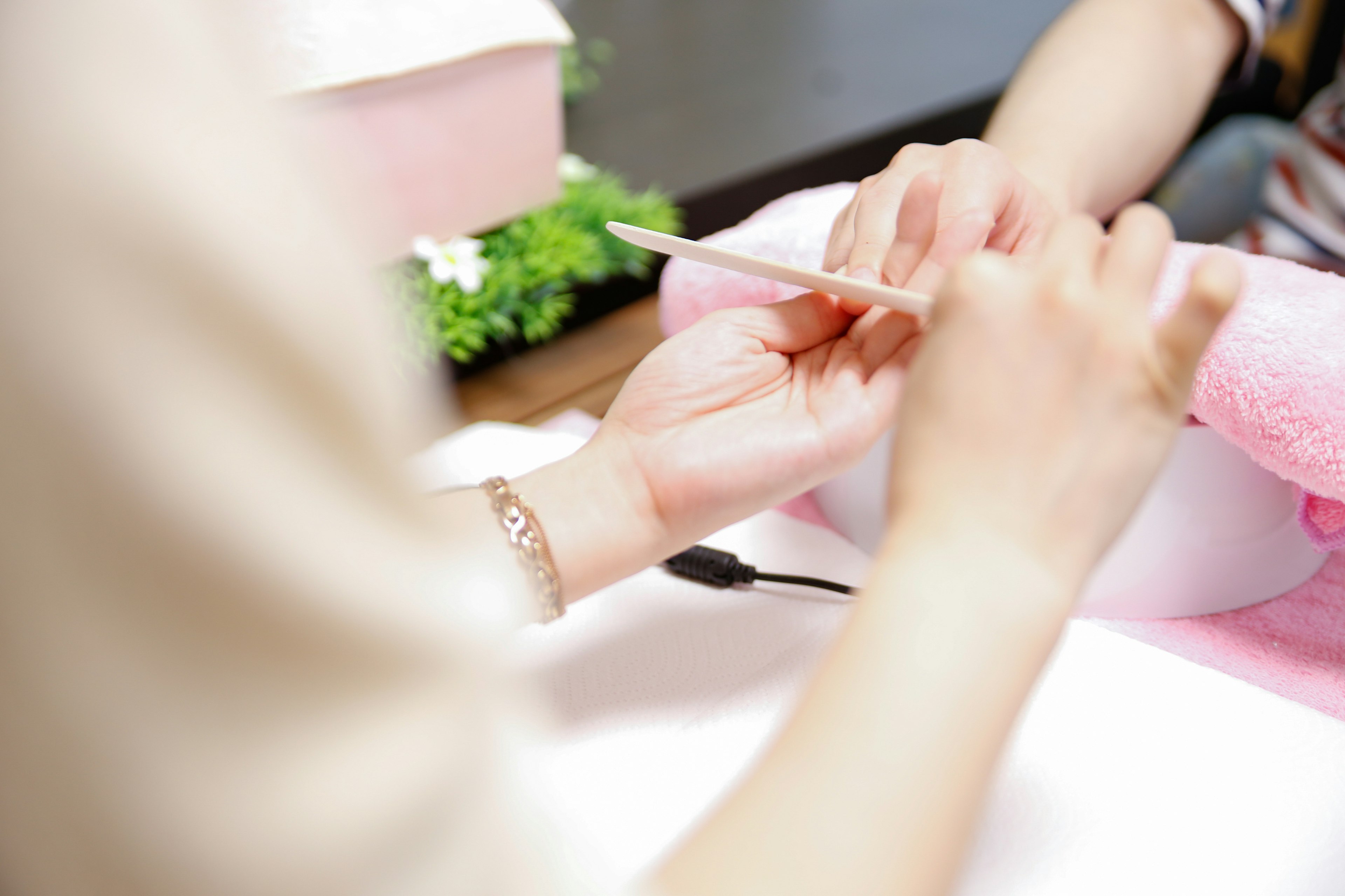 Mains recevant des soins des ongles avec une lime à ongles