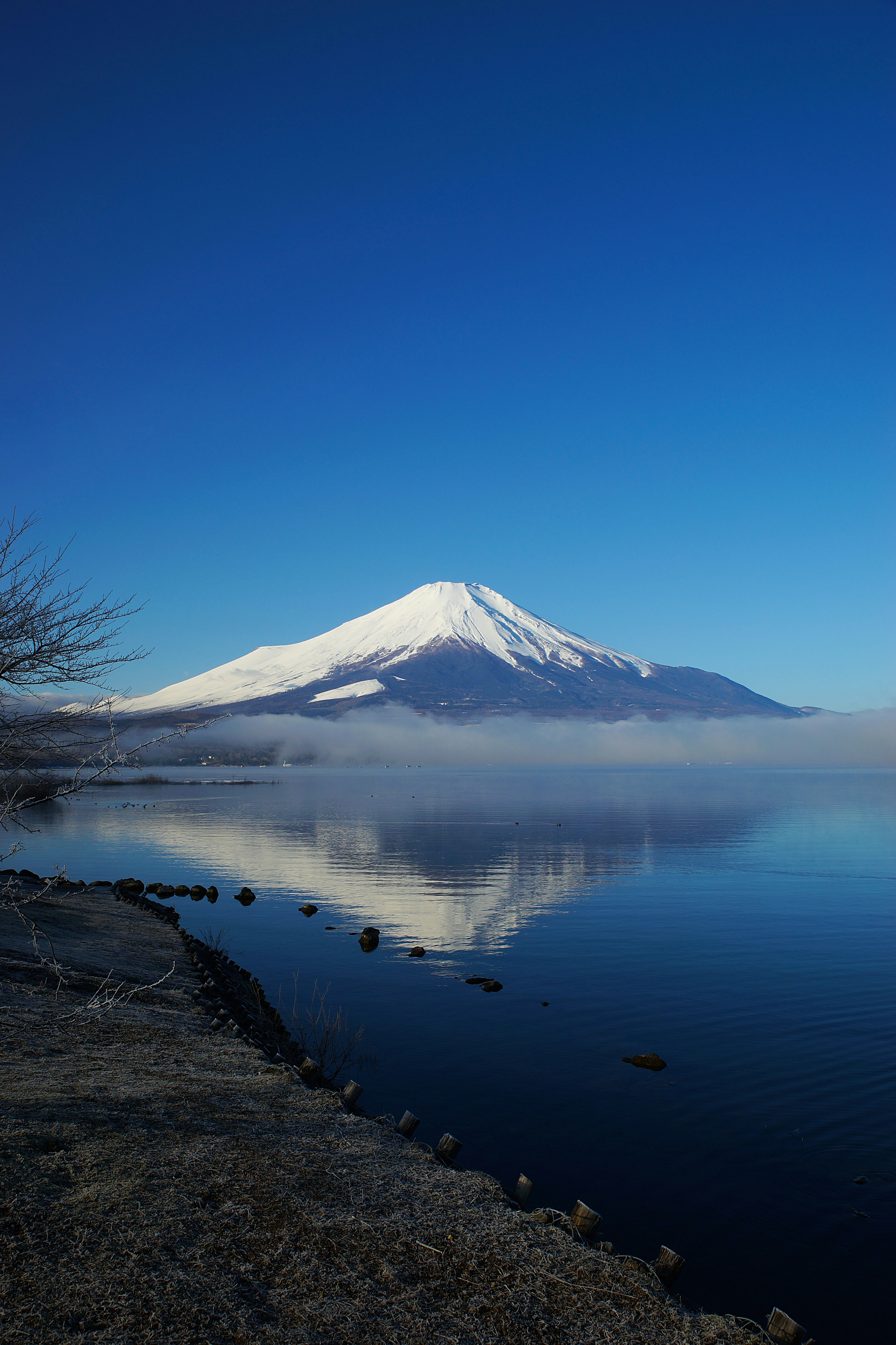 Hermoso Monte Fuji bajo un cielo azul claro reflejándose en el agua