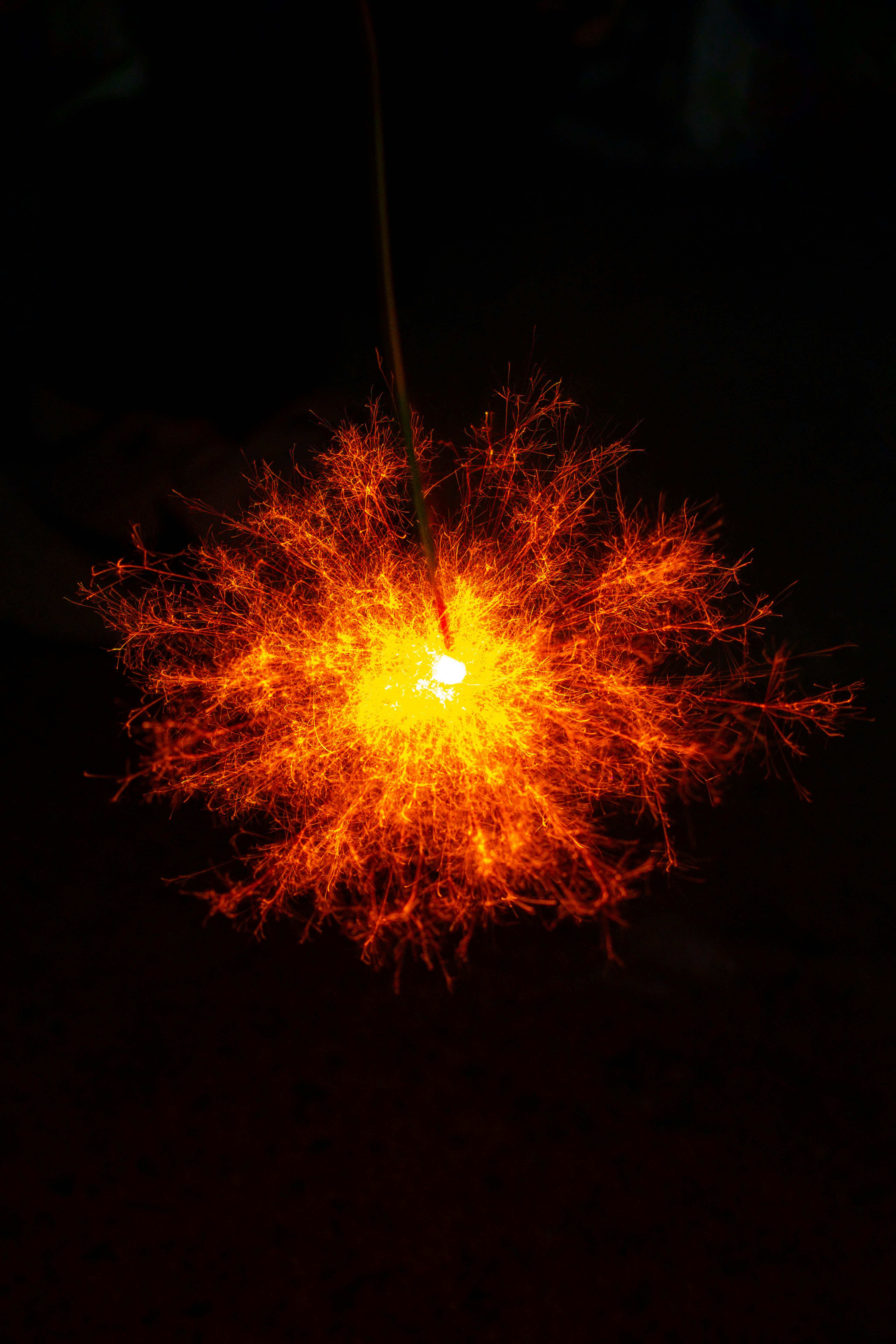 Ein funkenartiges Objekt, das orange Licht vor einem dunklen Hintergrund ausstrahlt