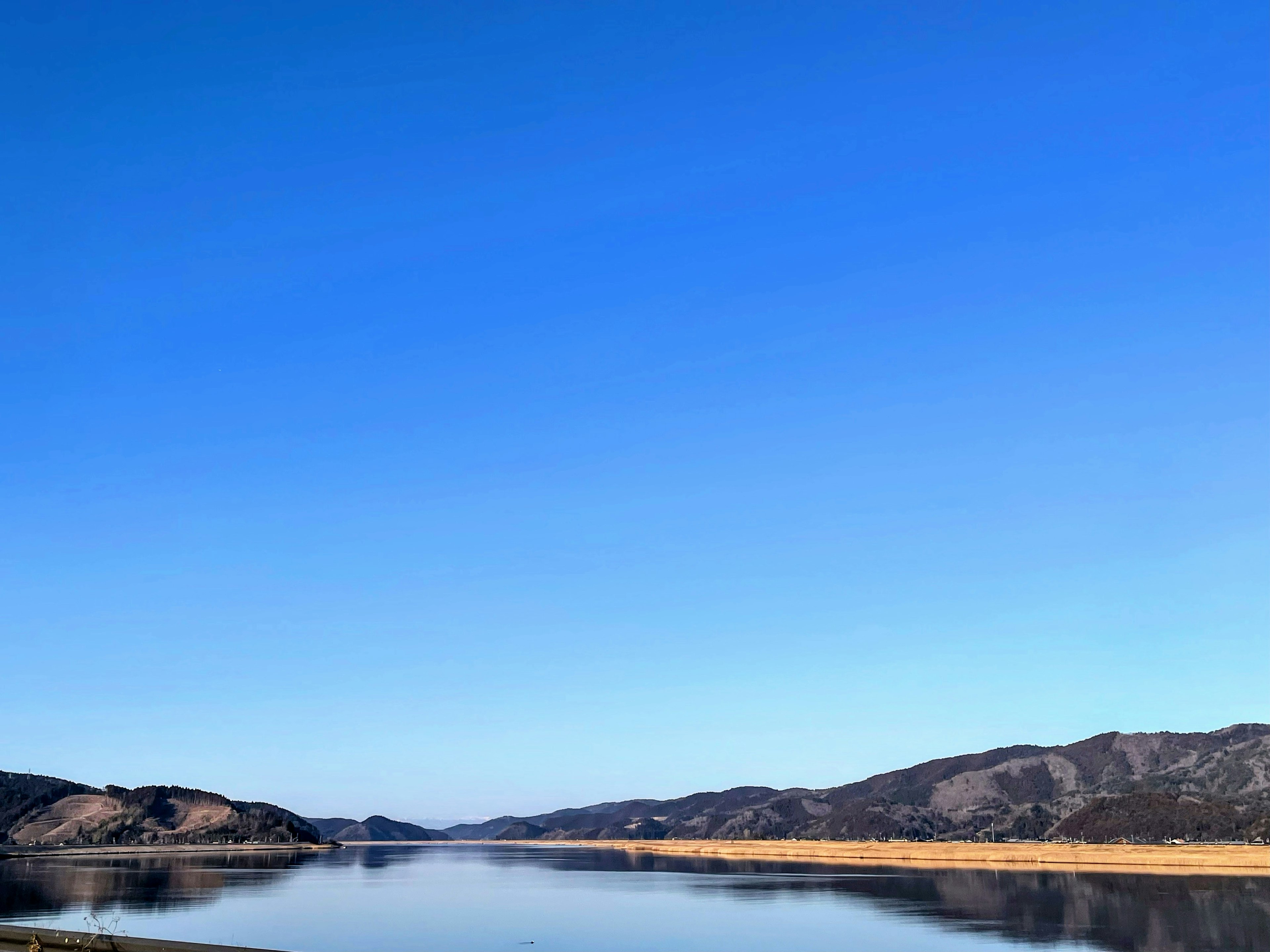 Un paesaggio sereno con cielo blu chiaro e fiume calmo