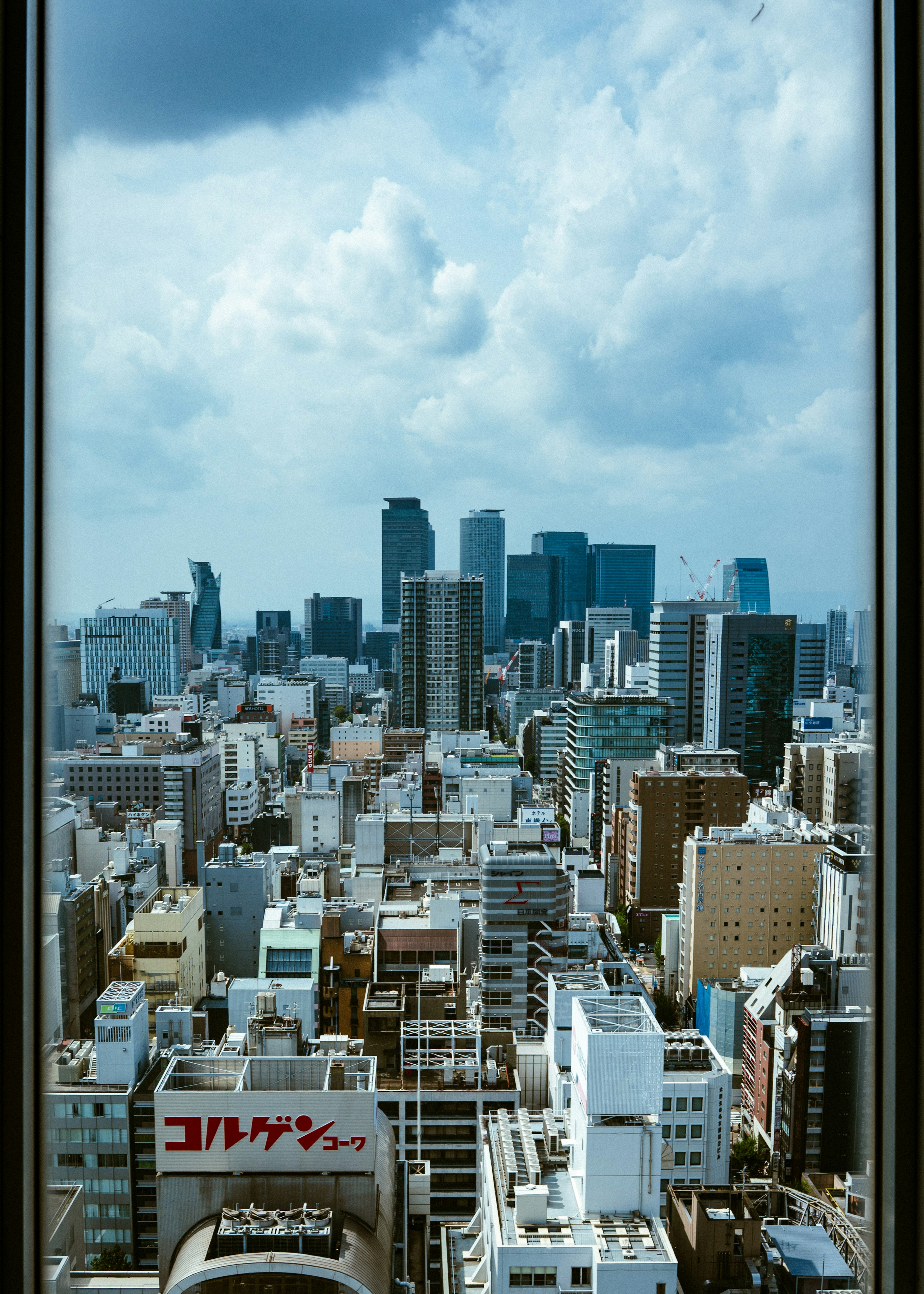 高層ビルが立ち並ぶ都市の風景と雲が広がる空