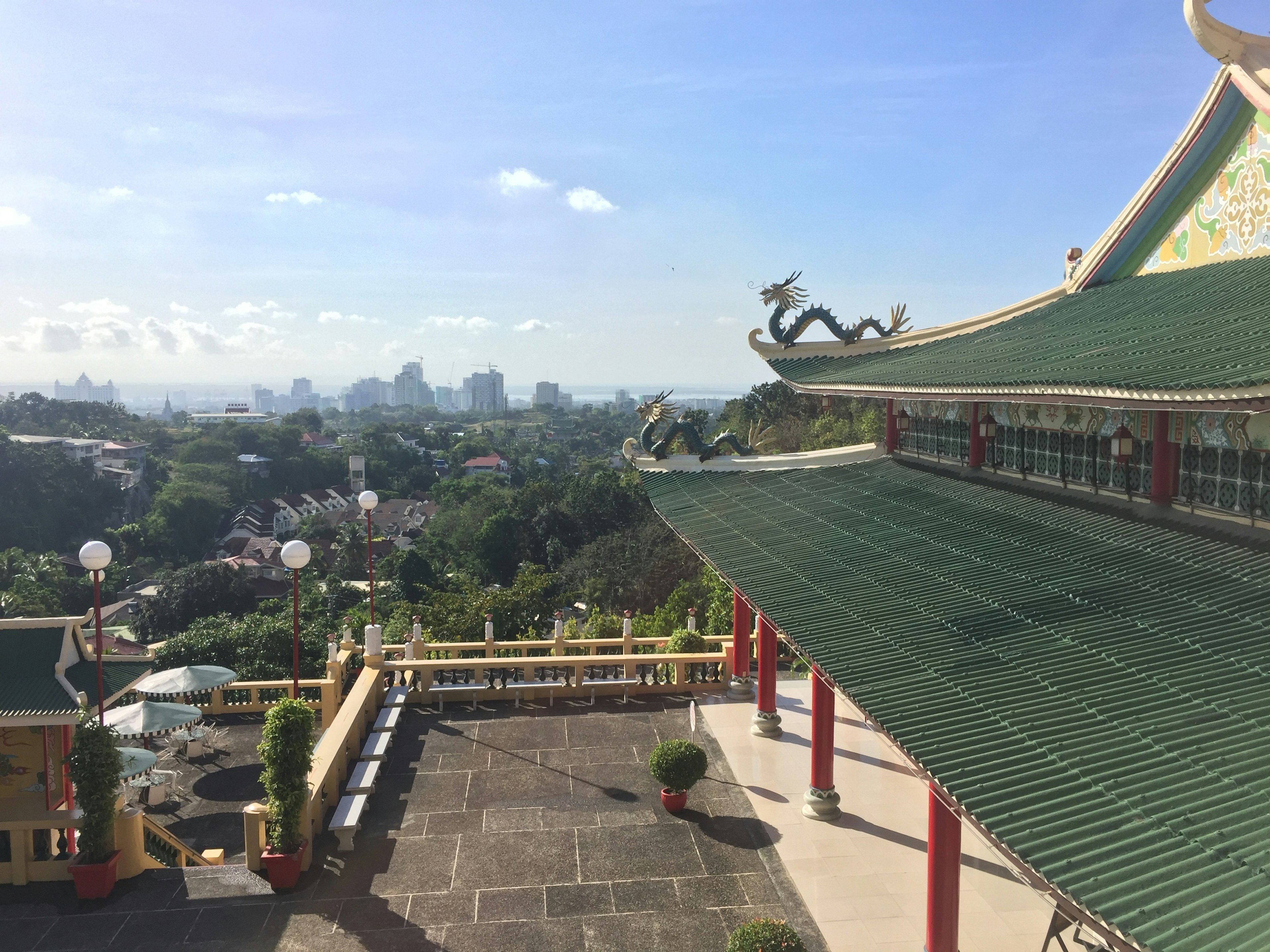 远眺城市风景的寺庙，绿色屋顶和龙的装饰