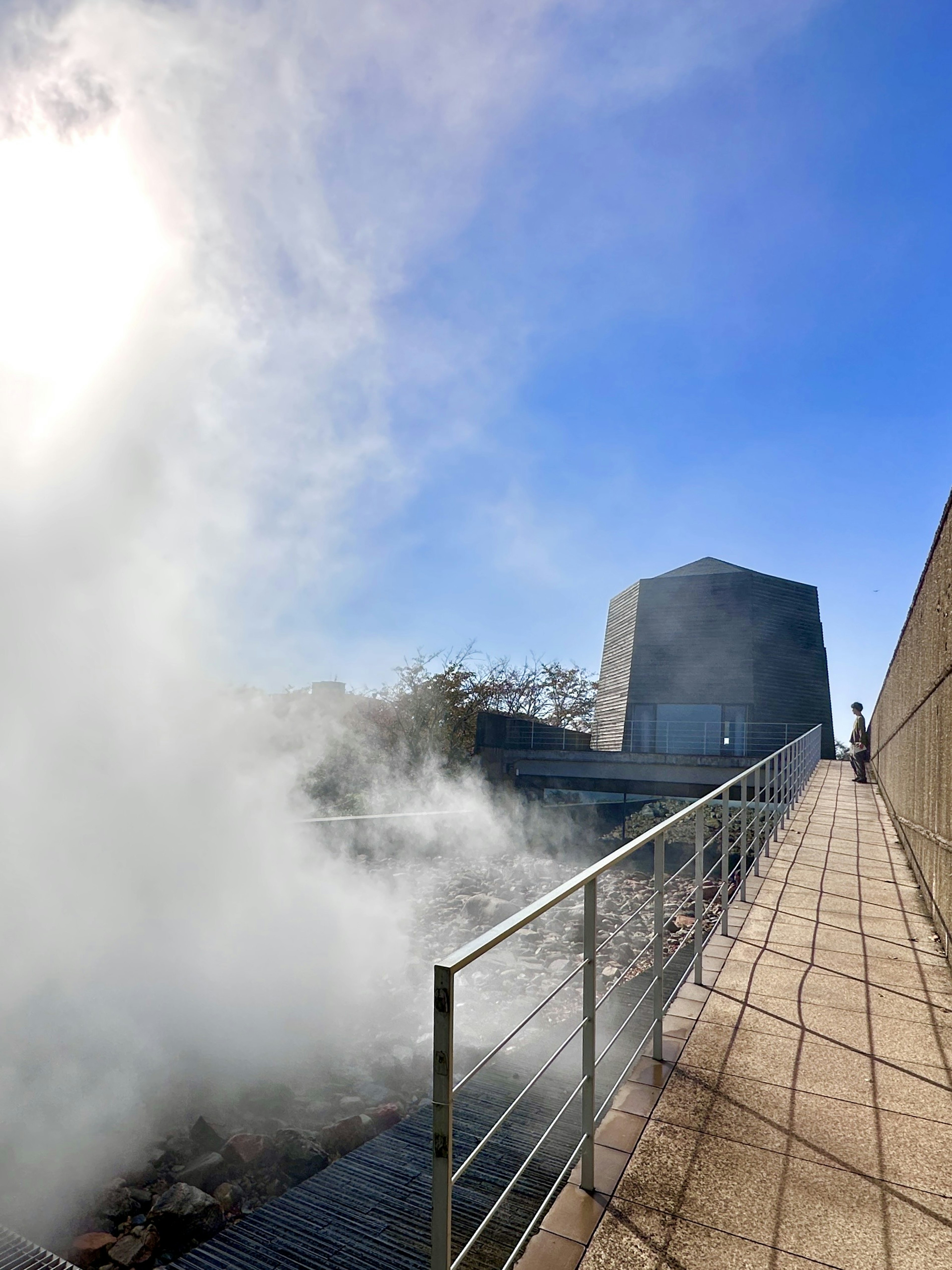 Edificio moderno e passerella nella nebbia sotto un cielo blu