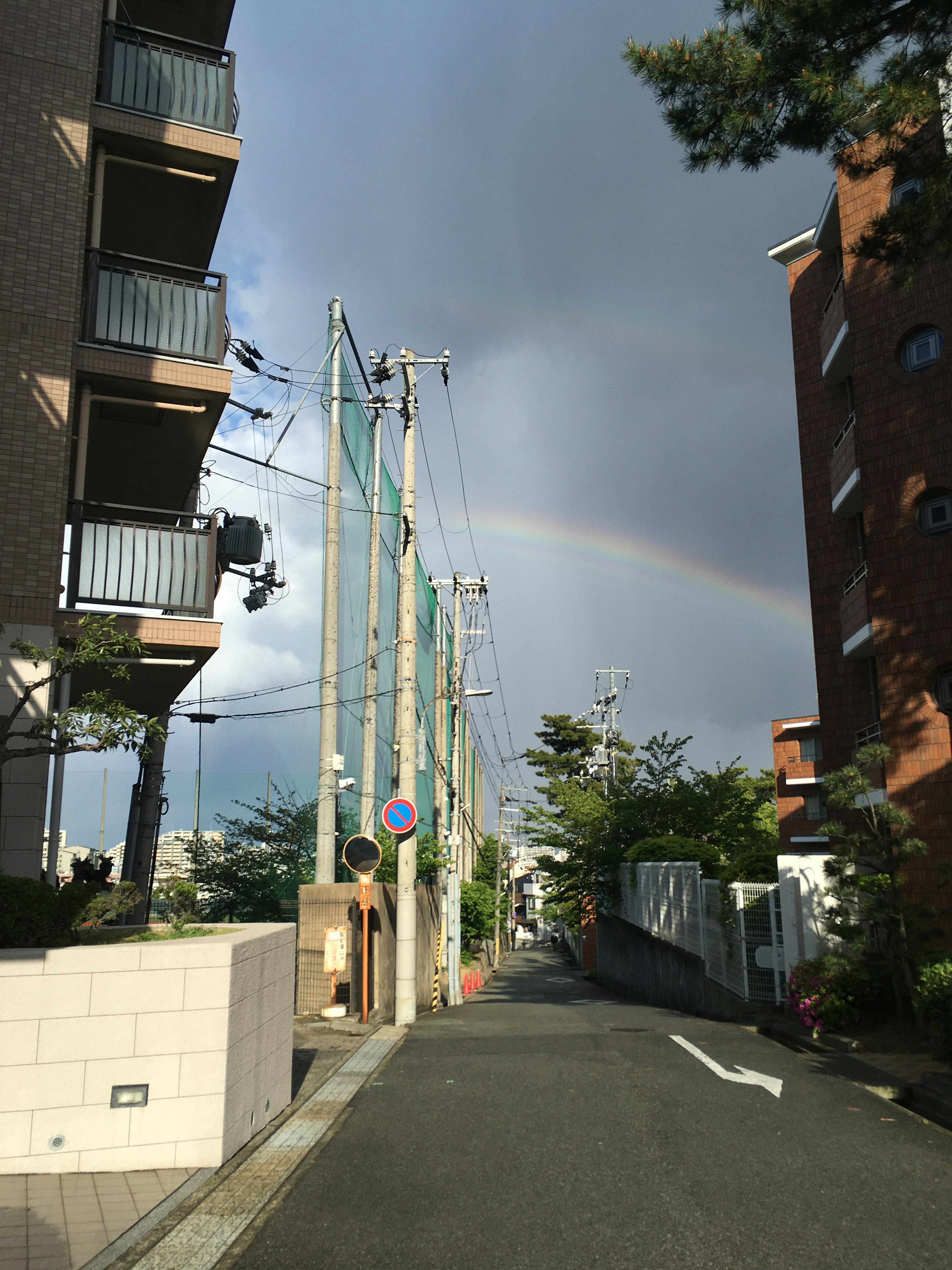 Ruhige Straße mit Gebäuden und sichtbarem Regenbogen