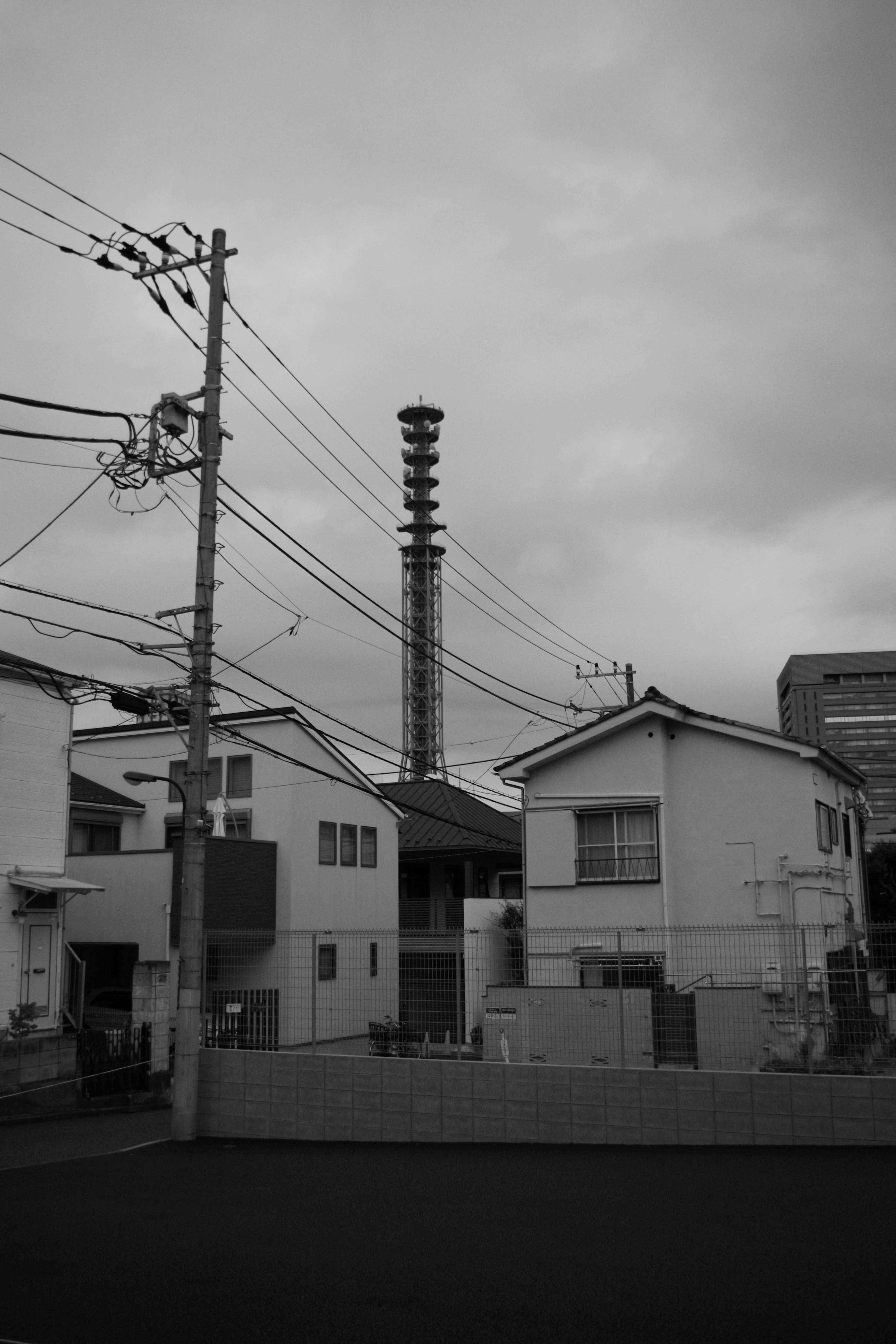 白黒の都市風景 電柱と住宅の構造物 工場の煙突と曇り空