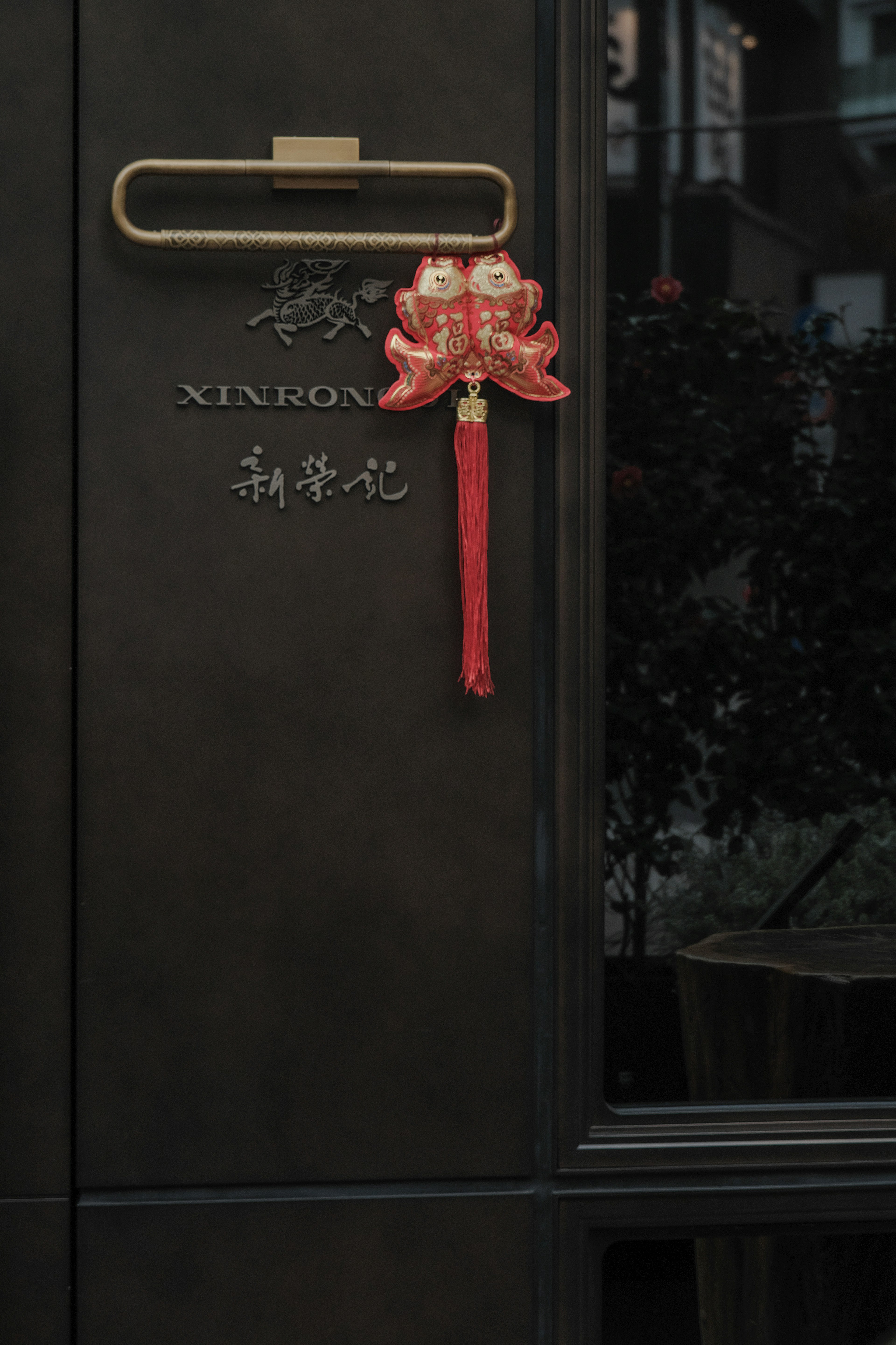 A black door featuring a decorative red ornament