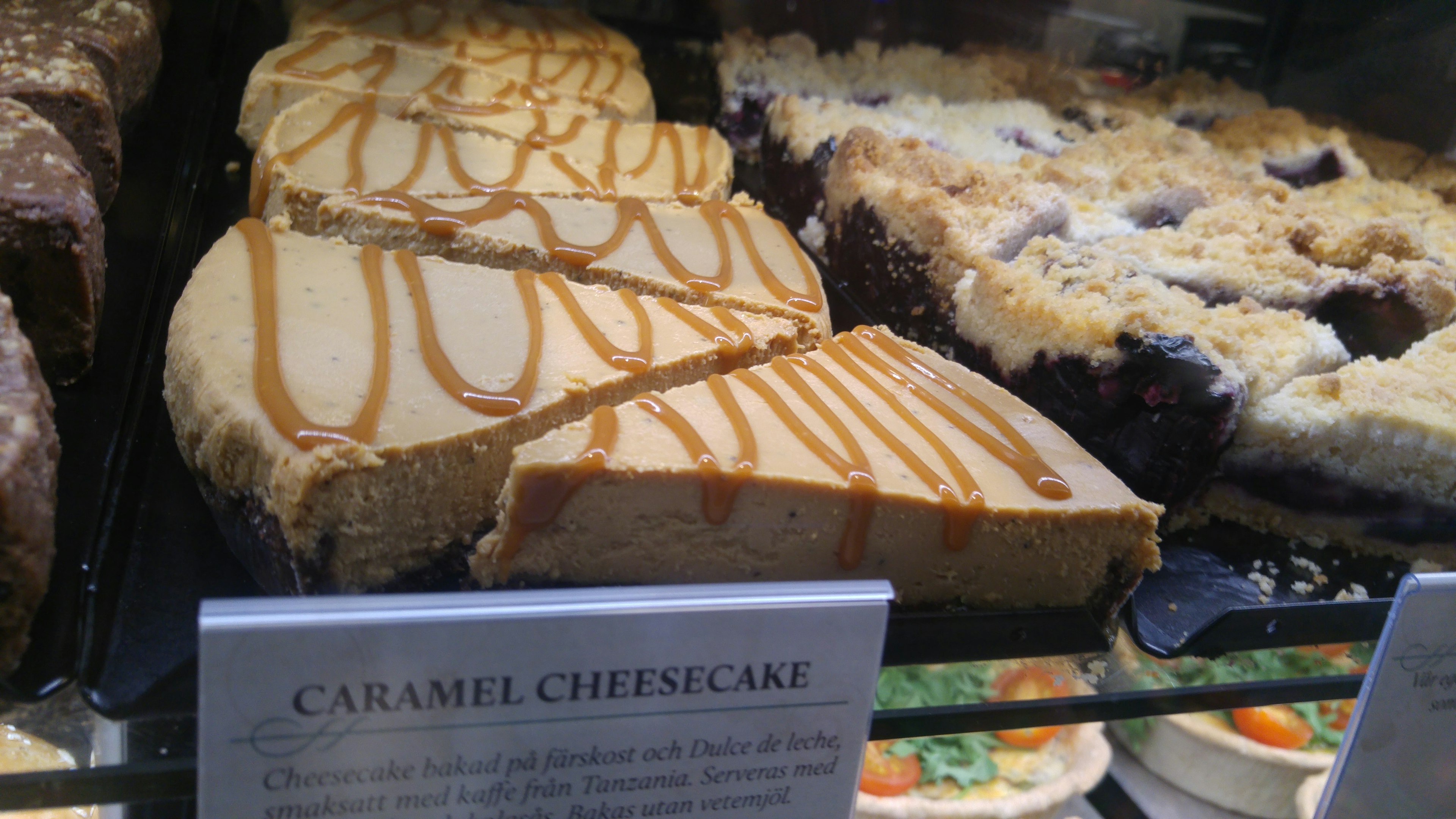 Rebanada de cheesecake de caramelo con caramelo rociado en exhibición