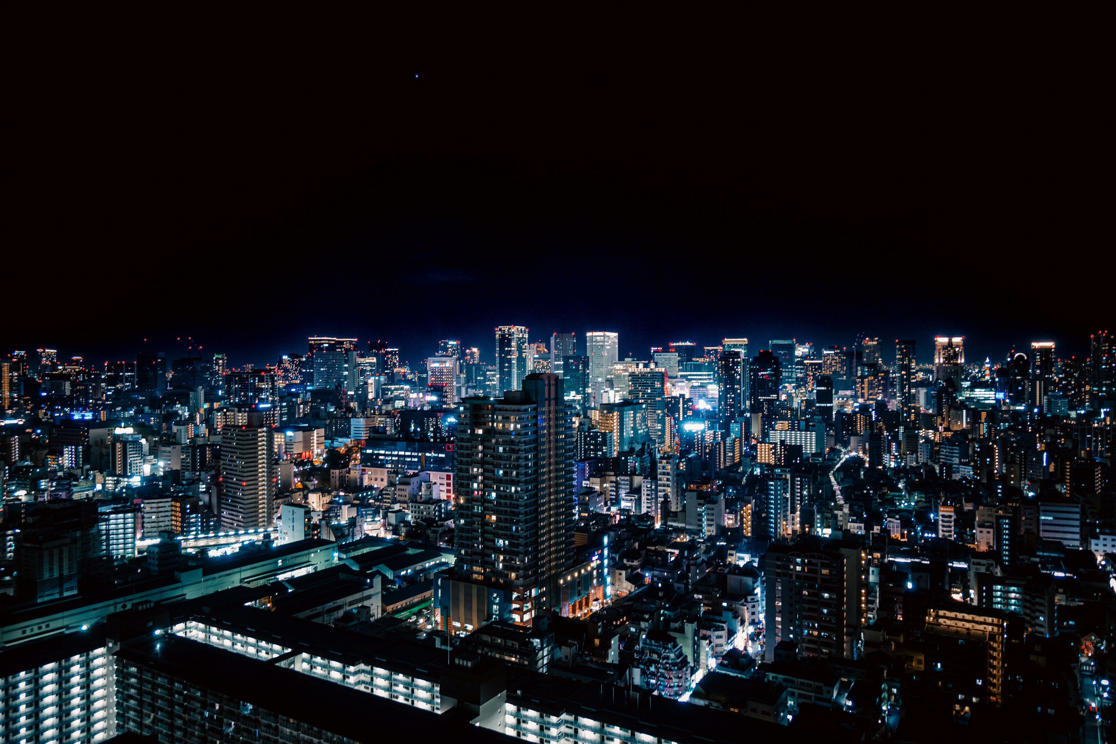 Panoramablick auf eine Stadt bei Nacht mit hohen Gebäuden und hellen Lichtern