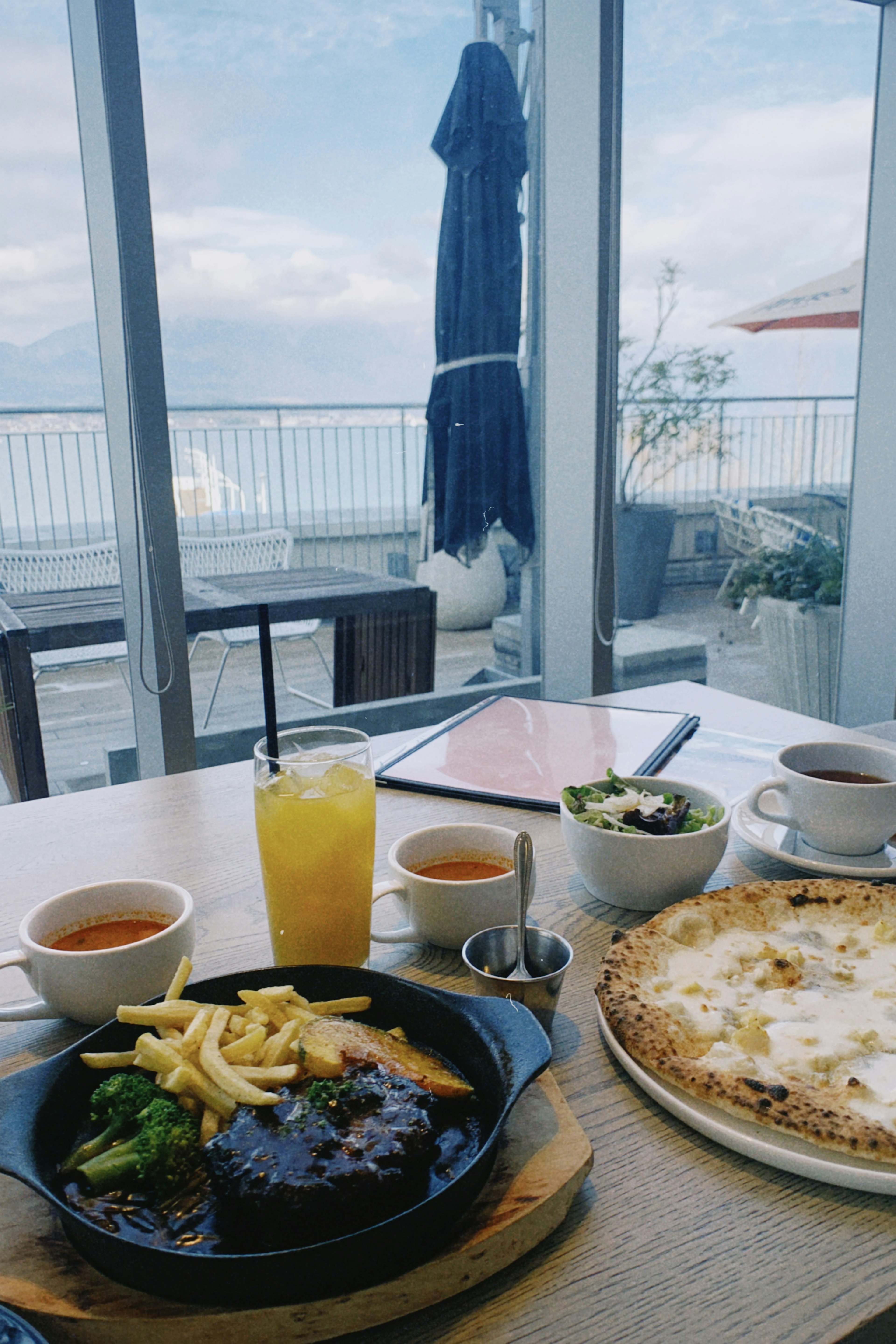 桌上的菜餚和飲料，背景是美麗的海景