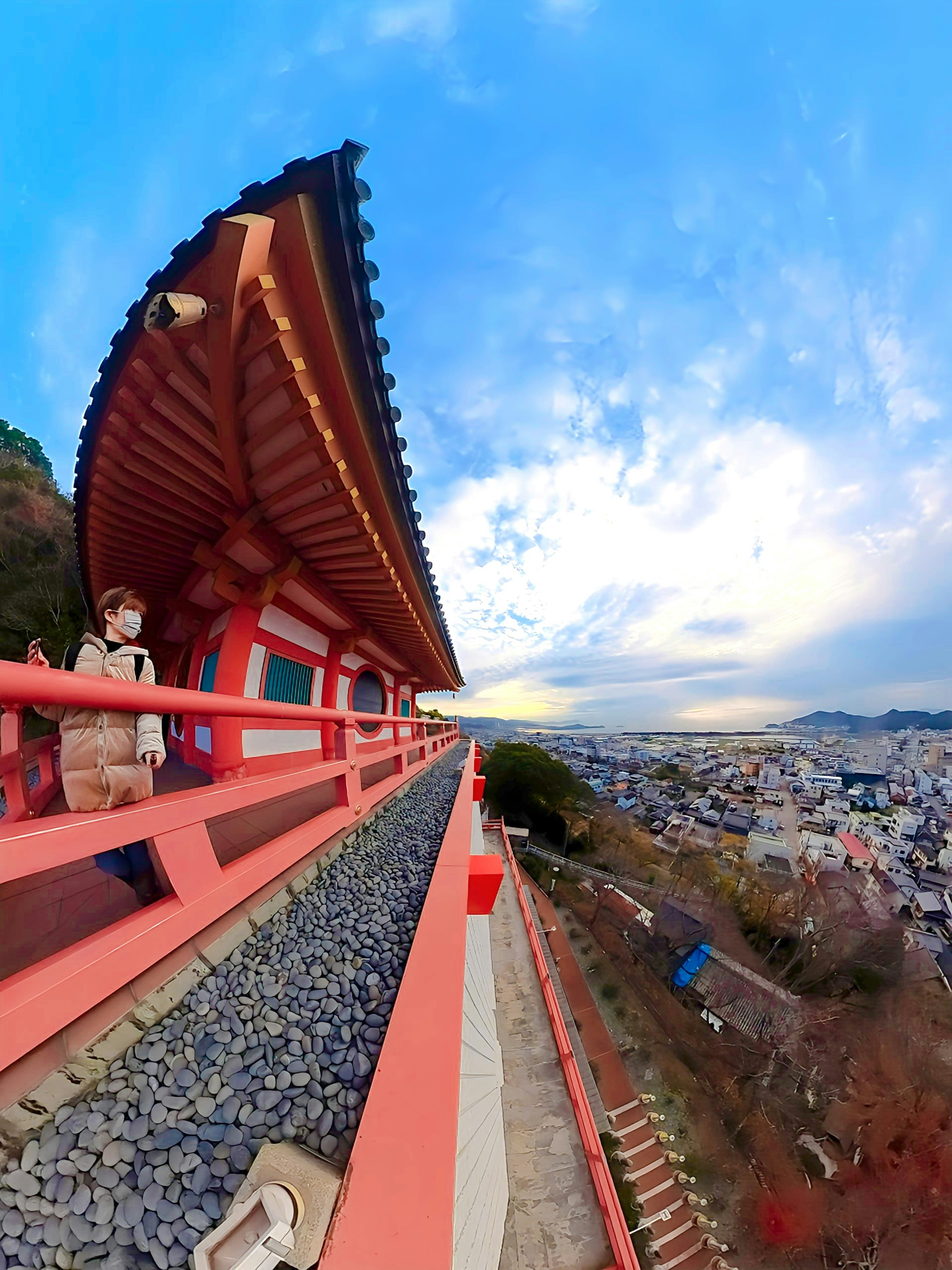 美しい景色を望む伝統的な日本の建物の屋根と赤い手すり