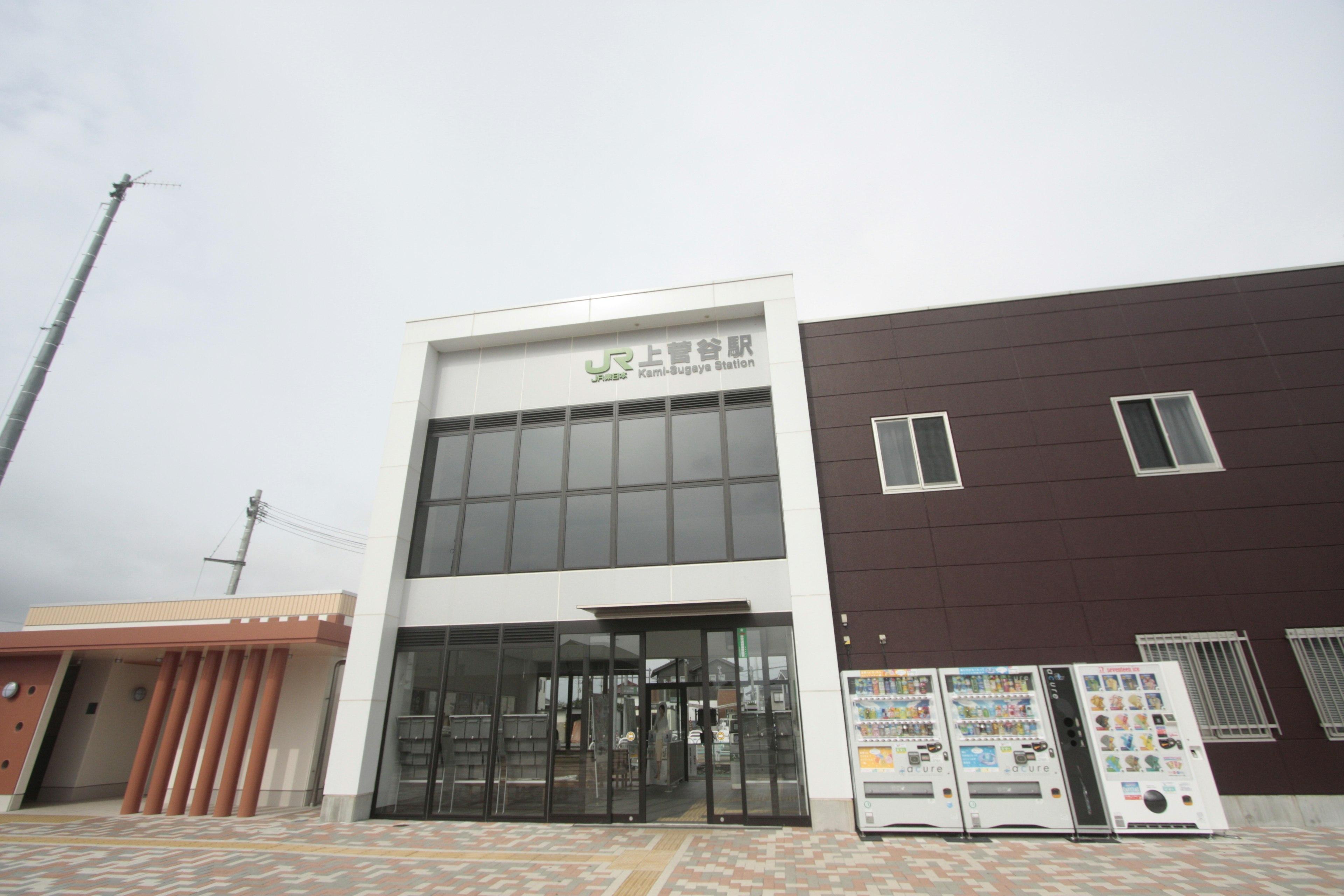 Modern building with white exterior large glass entrance right side brown wall section