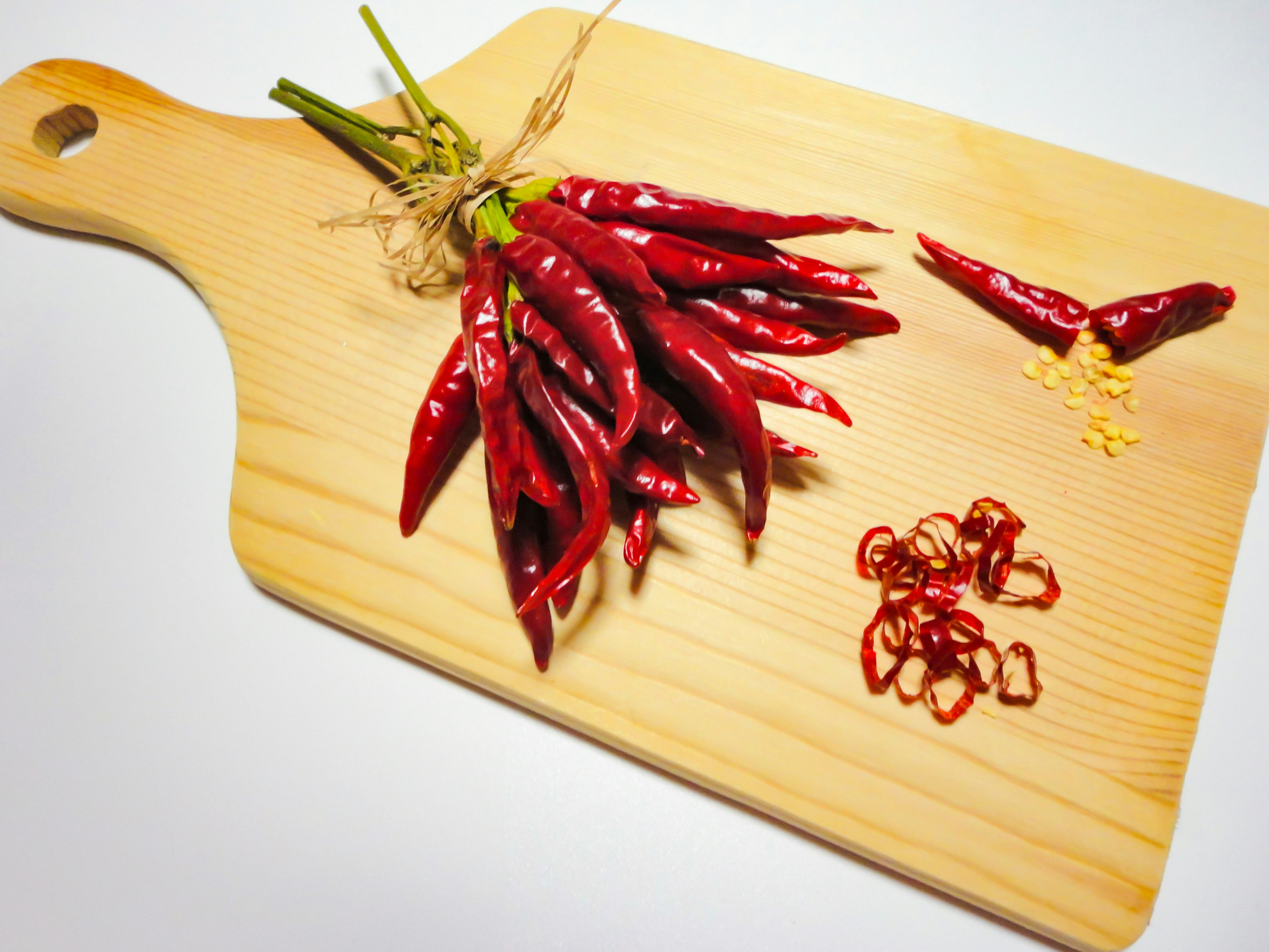 A bundle of red chili peppers placed on a wooden cutting board