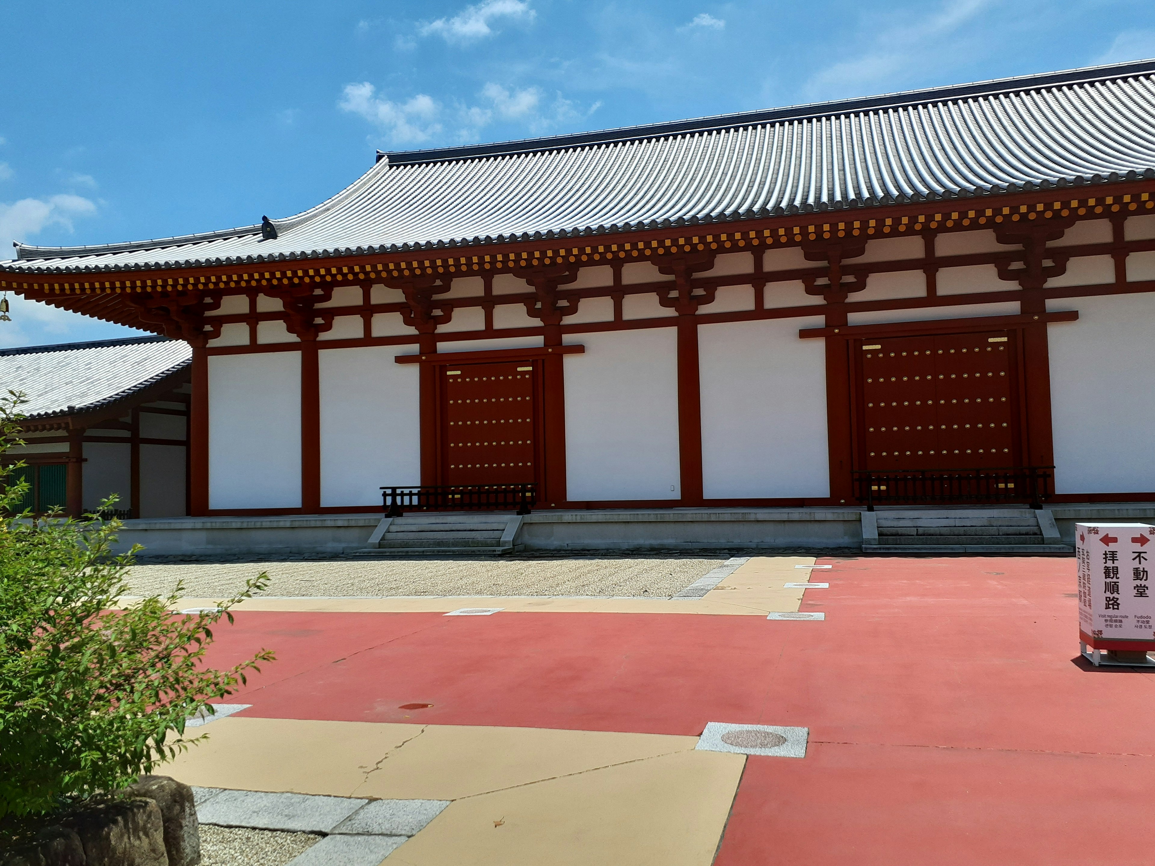 Bâtiment japonais traditionnel avec des murs rouges et un toit en tuiles