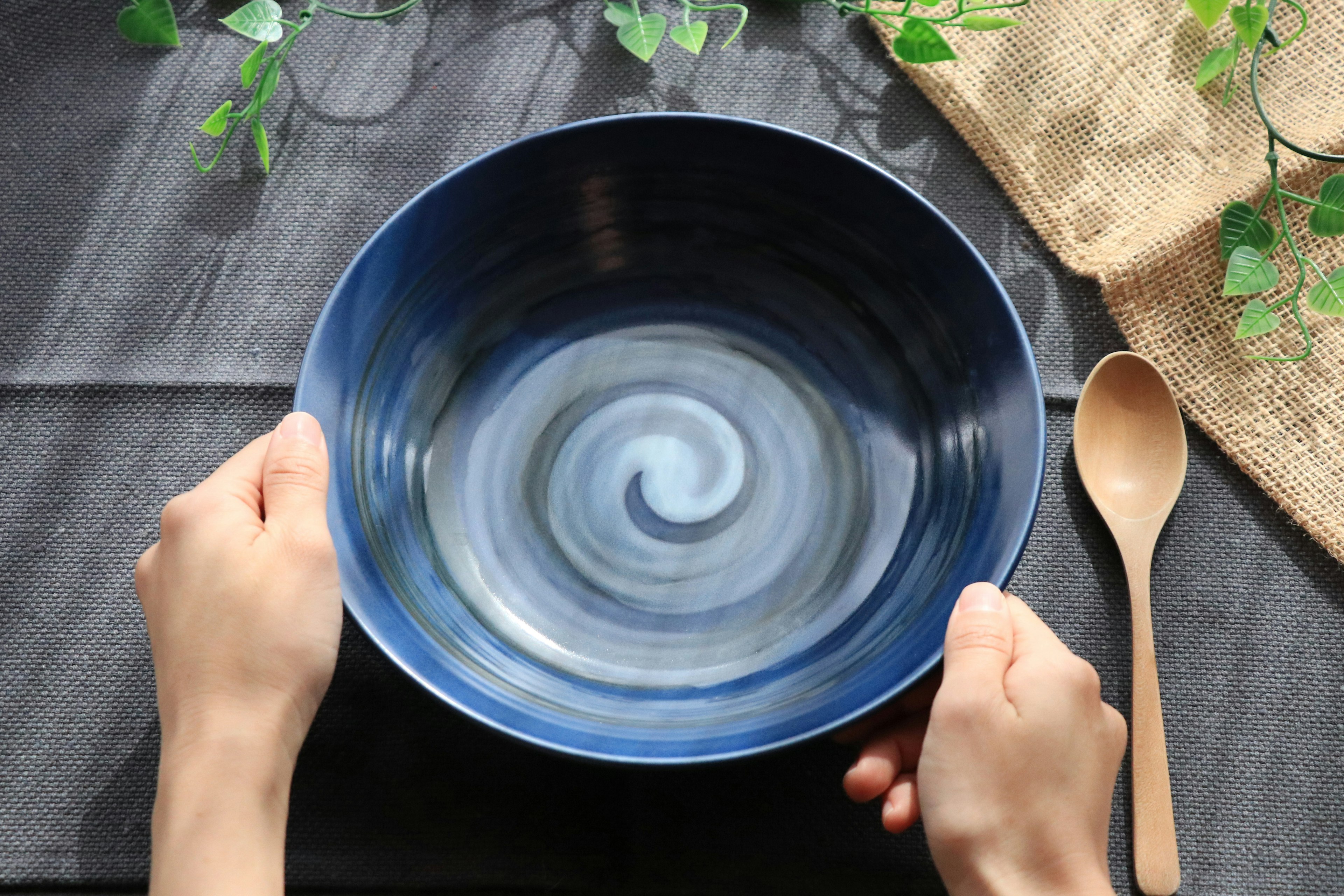 Hands holding a blue swirling patterned bowl