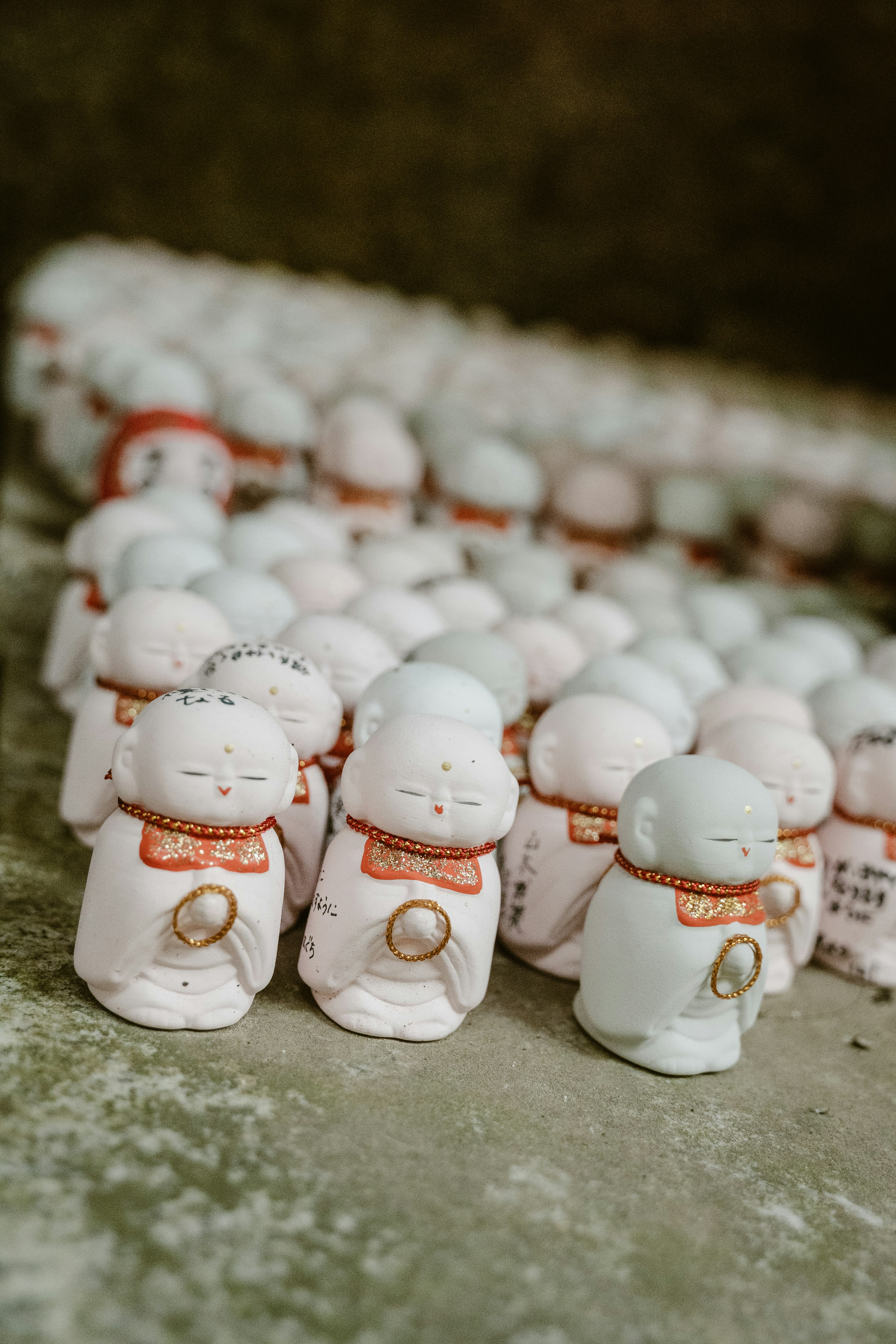 Small white figurines of Buddha lined up in rows