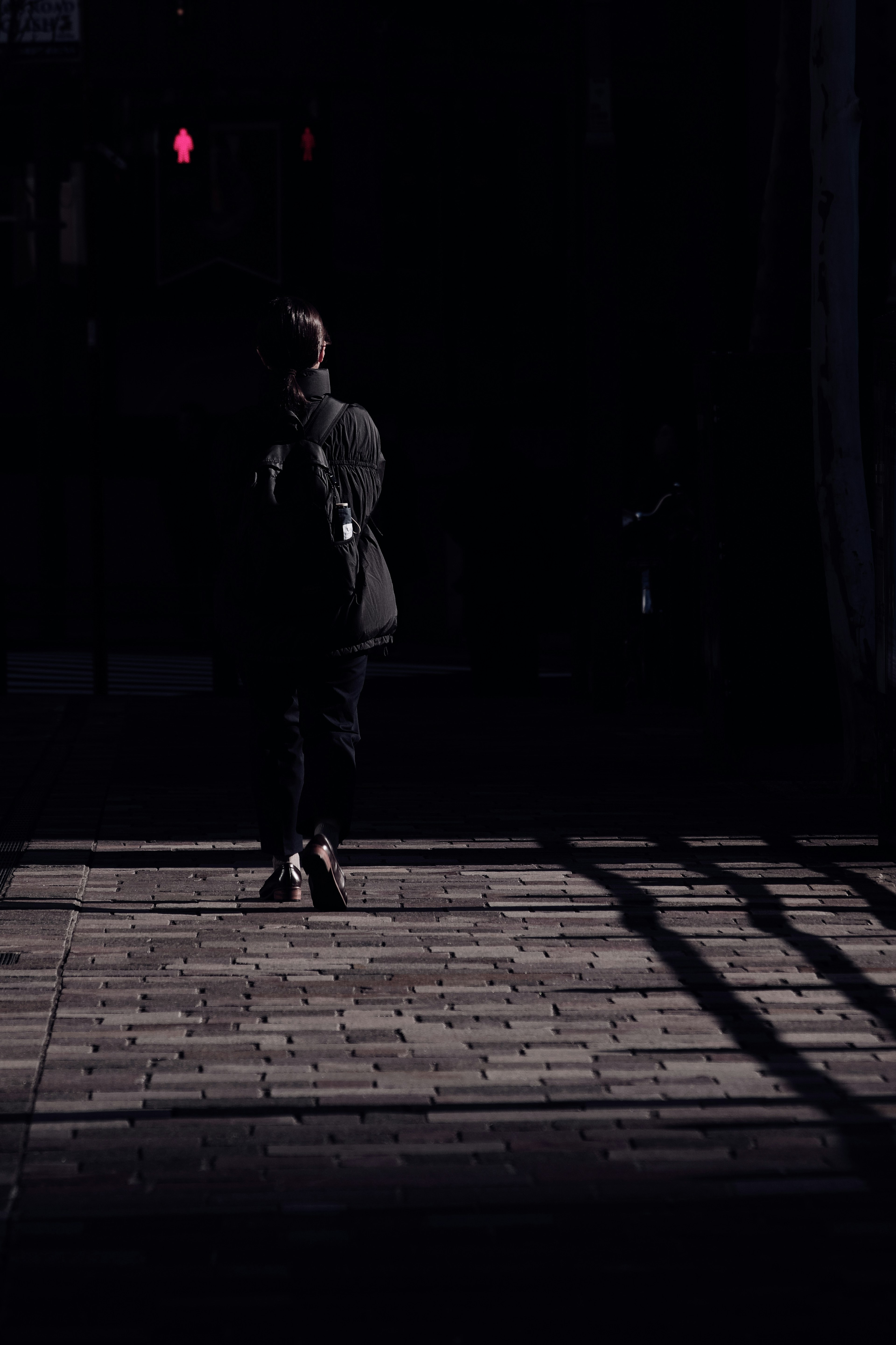 Silhouette of a person walking against a dark background