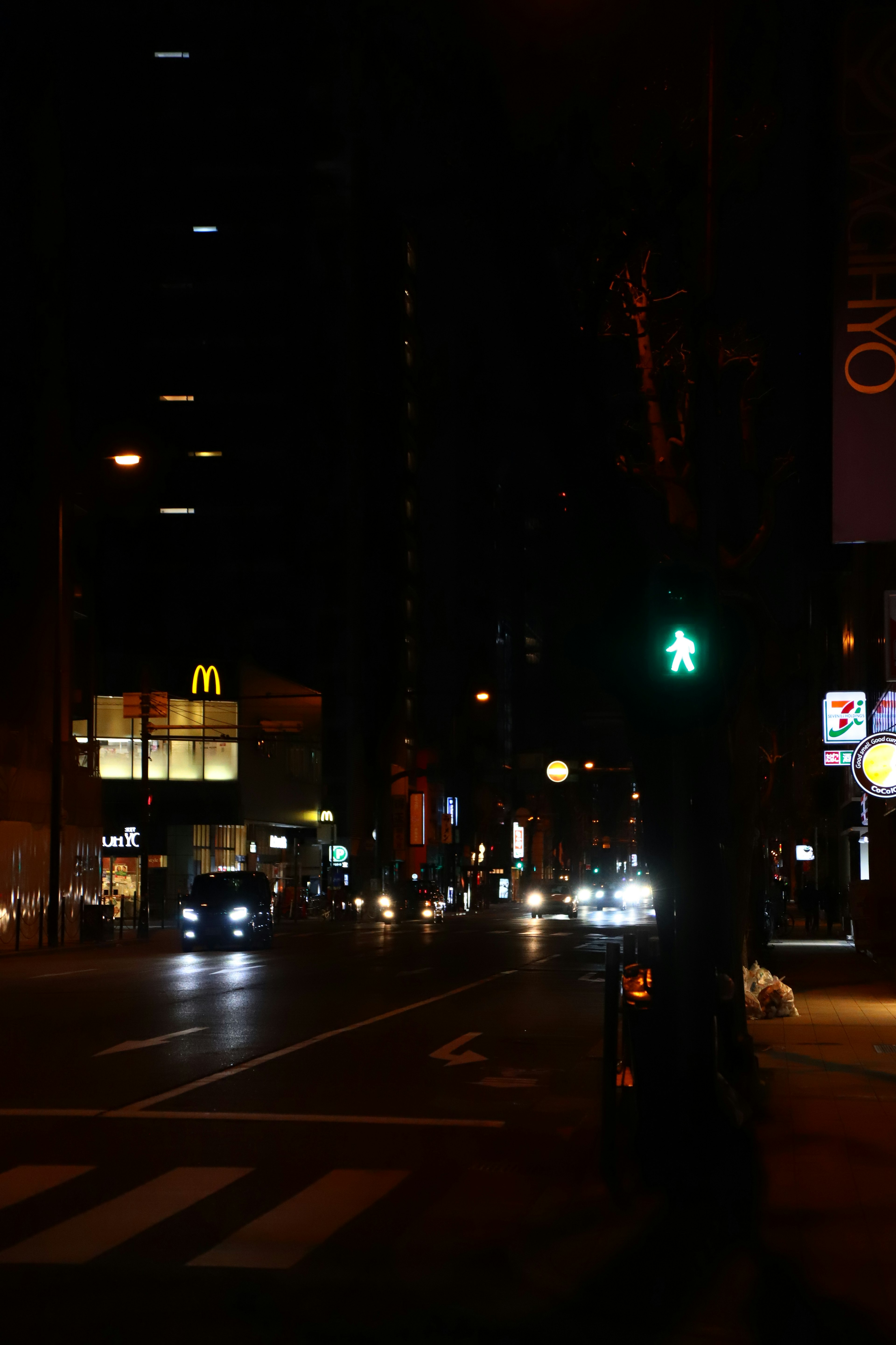 Angolo di strada di notte con semaforo e McDonald's illuminato