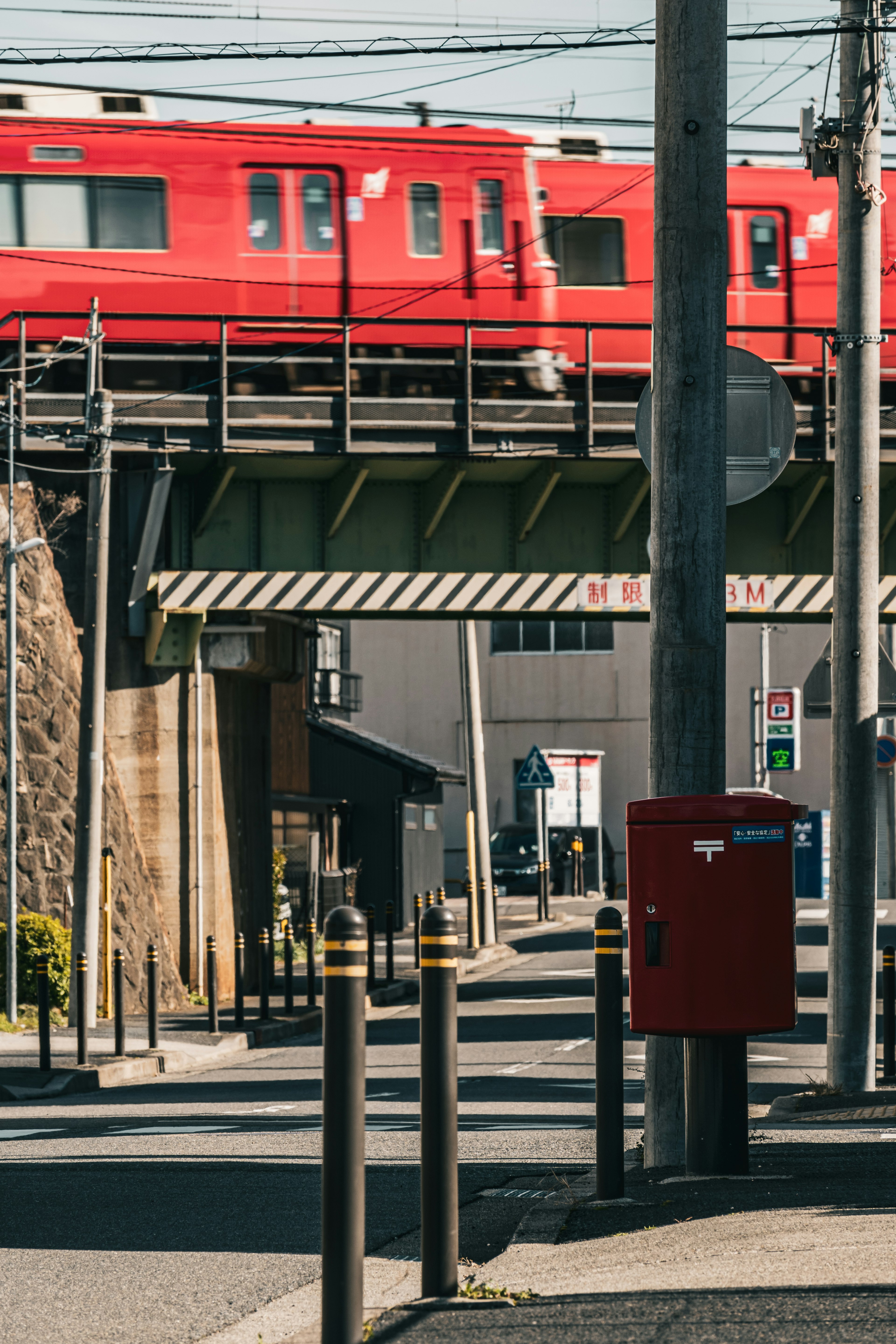 Red train running on an elevated track in an urban setting