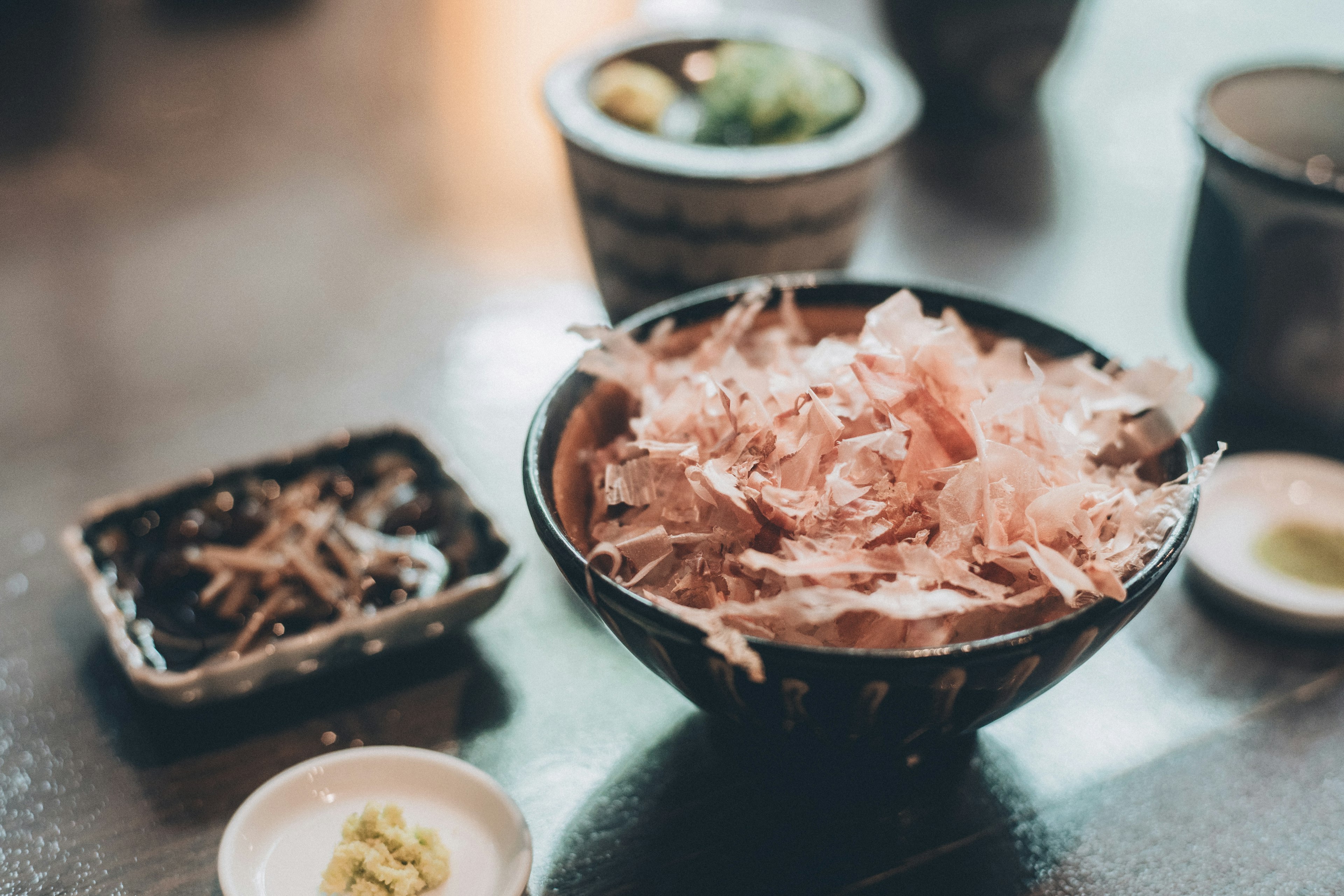 Bol de flocons de bonite avec wasabi et plats d'accompagnement sur une table