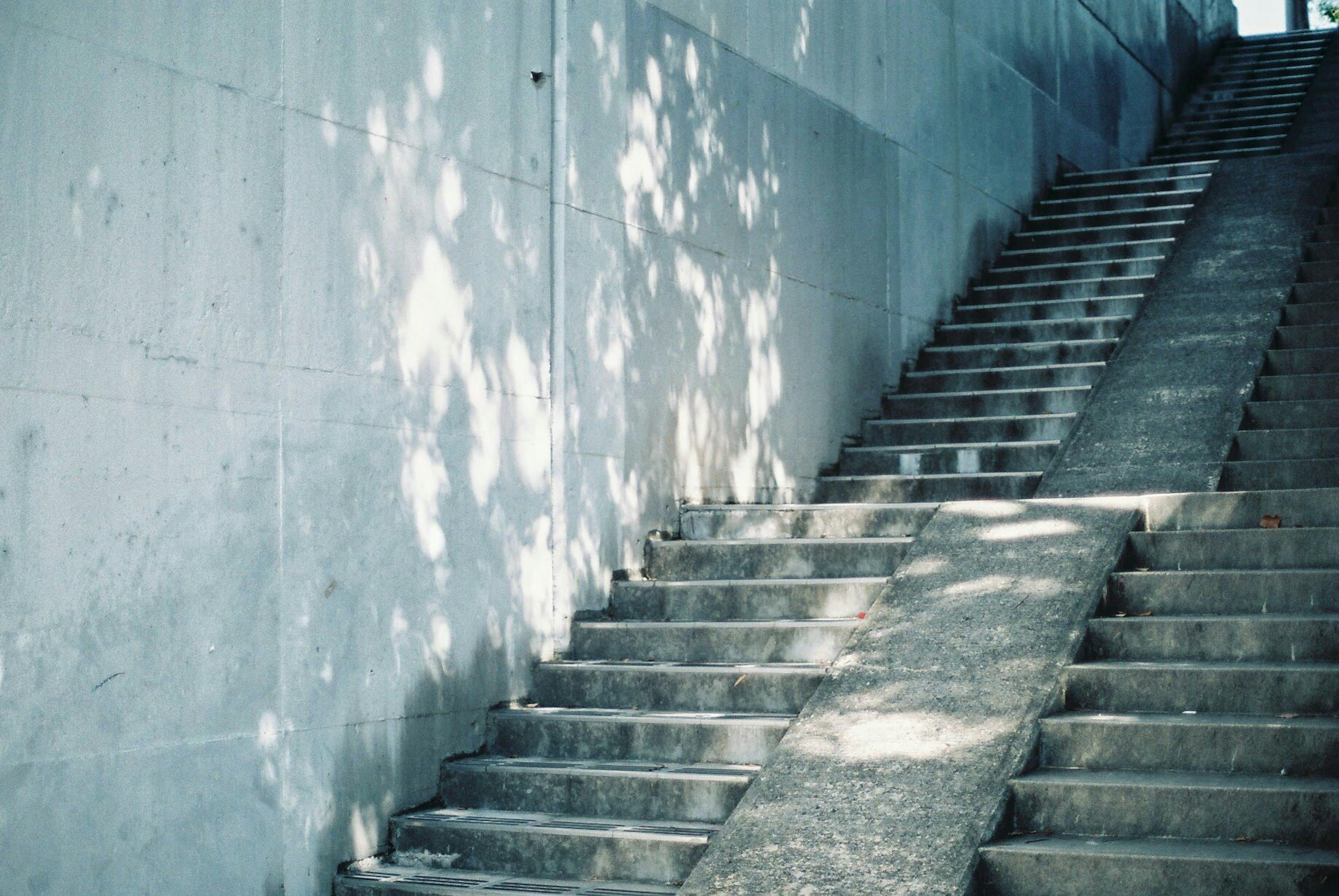 Escalier en béton avec des motifs de lumière sur le mur