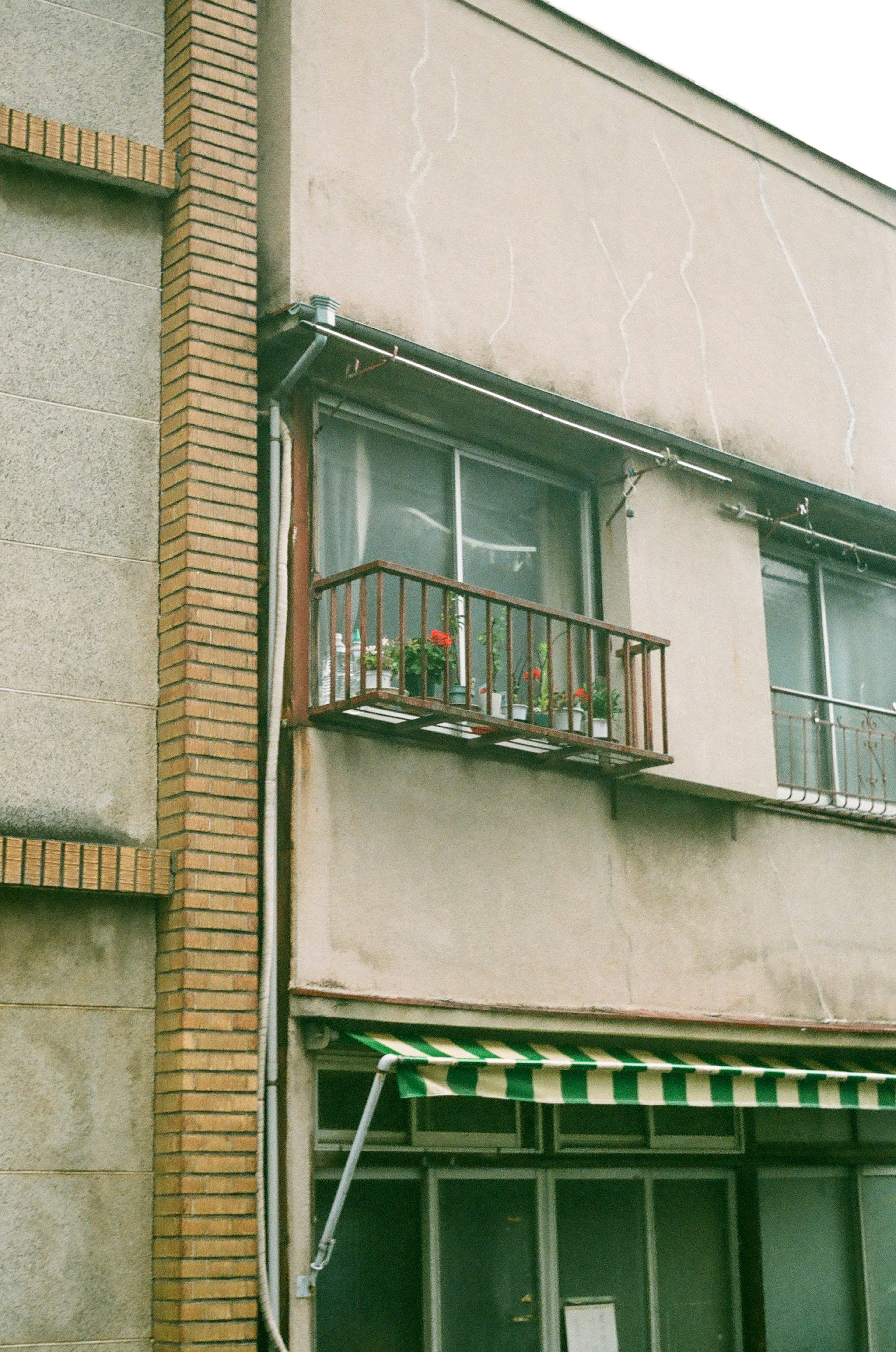 Un vieux bâtiment avec un balcon et des fleurs en pot