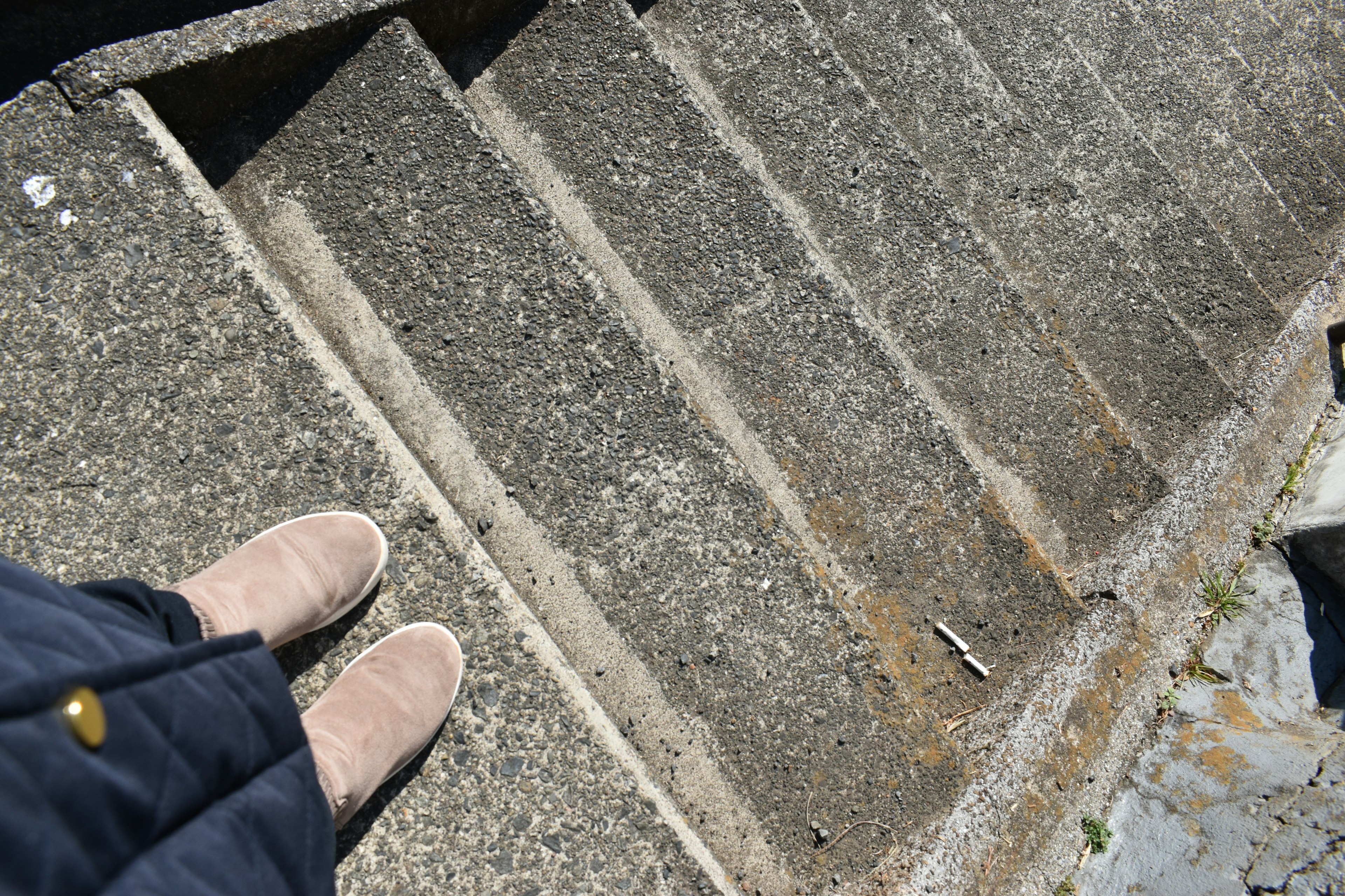 Photo vue du haut des escaliers avec des chaussures beiges en bas