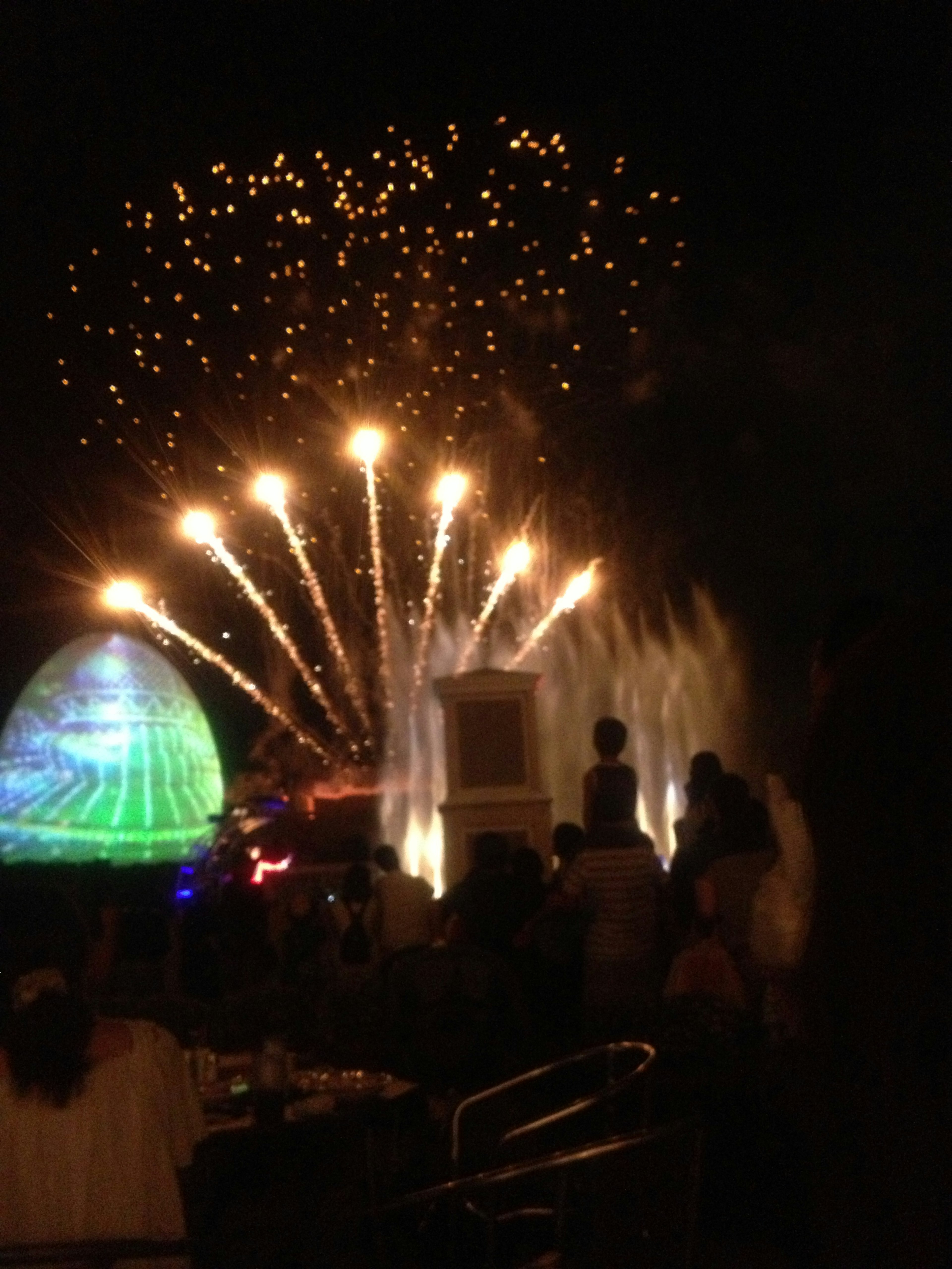 Zuschauer genießen eine Feuerwerks- und Springbrunnen-Show bei Nacht