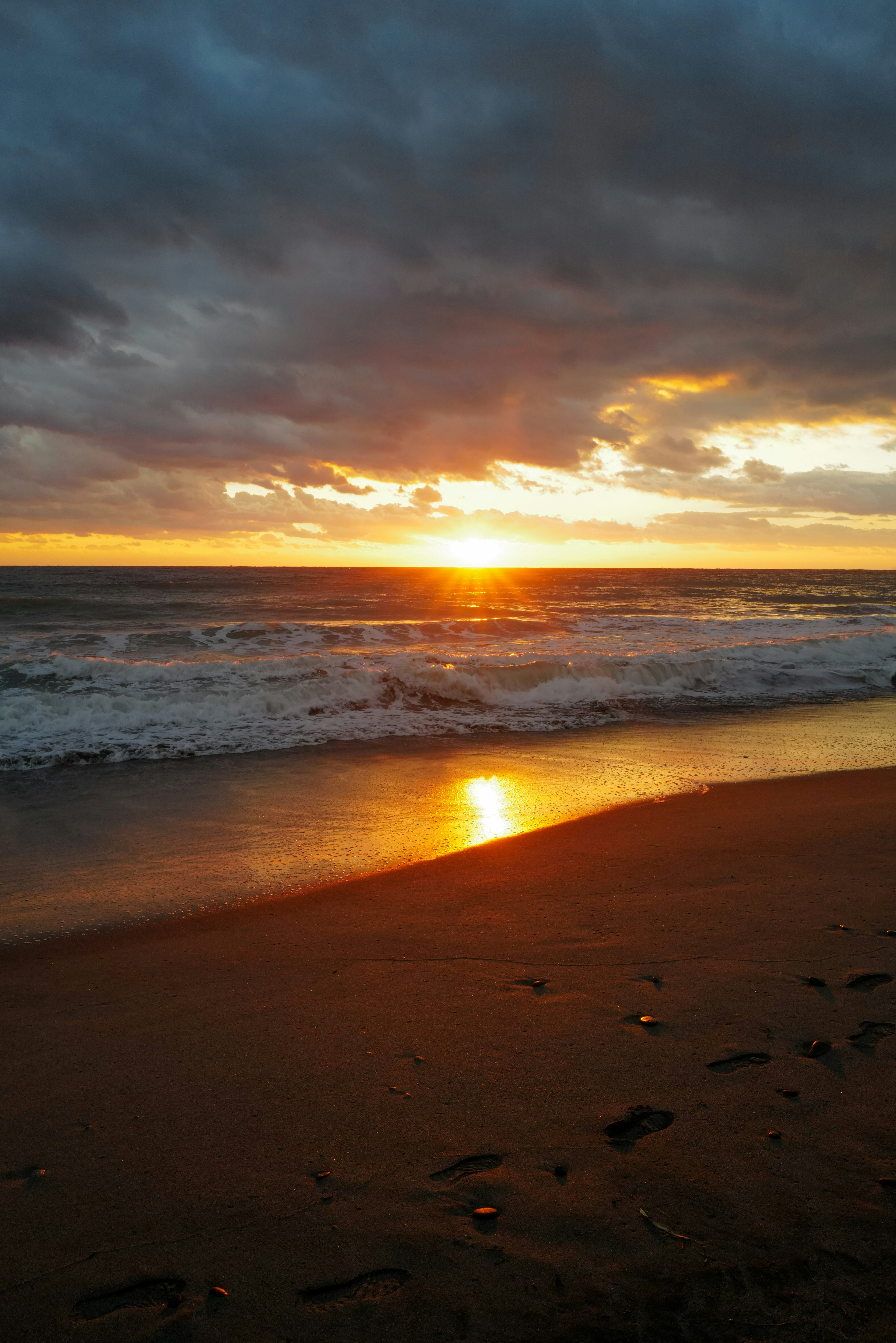 夕日が海に沈むビーチの風景