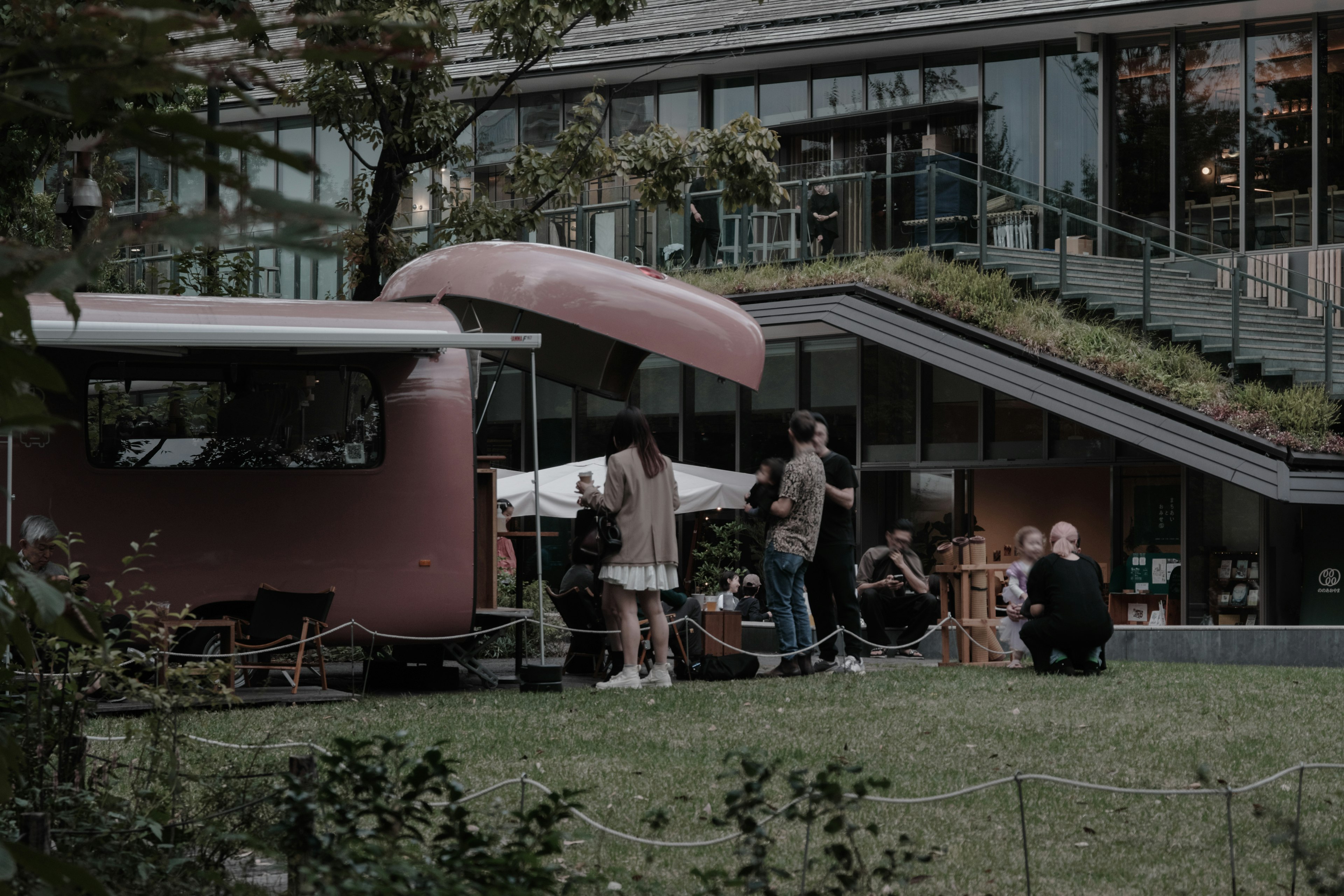 Camion de nourriture rose dans un parc avec des gens rassemblés