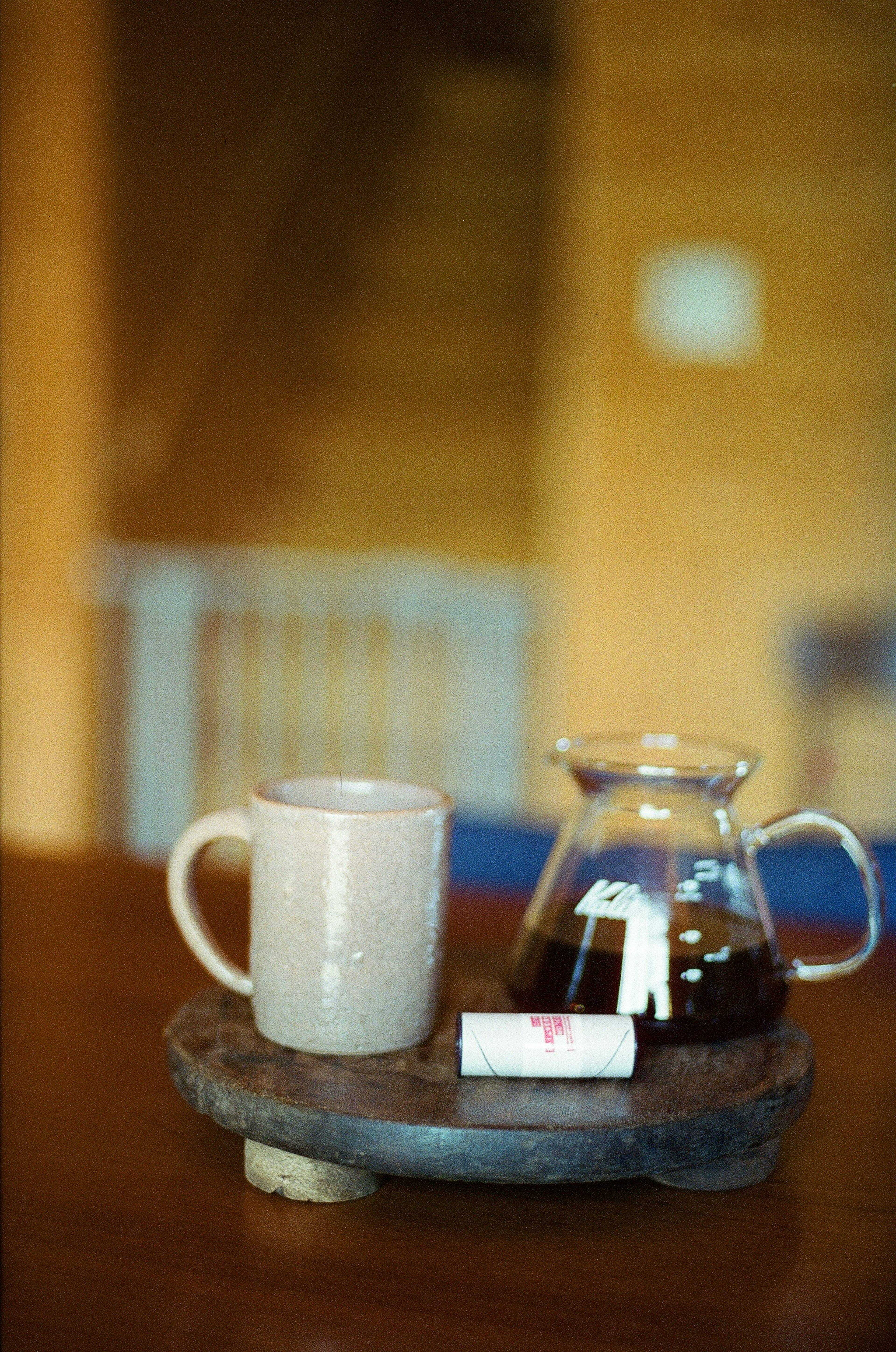 A glass coffee pot and a ceramic mug placed on a wooden tray