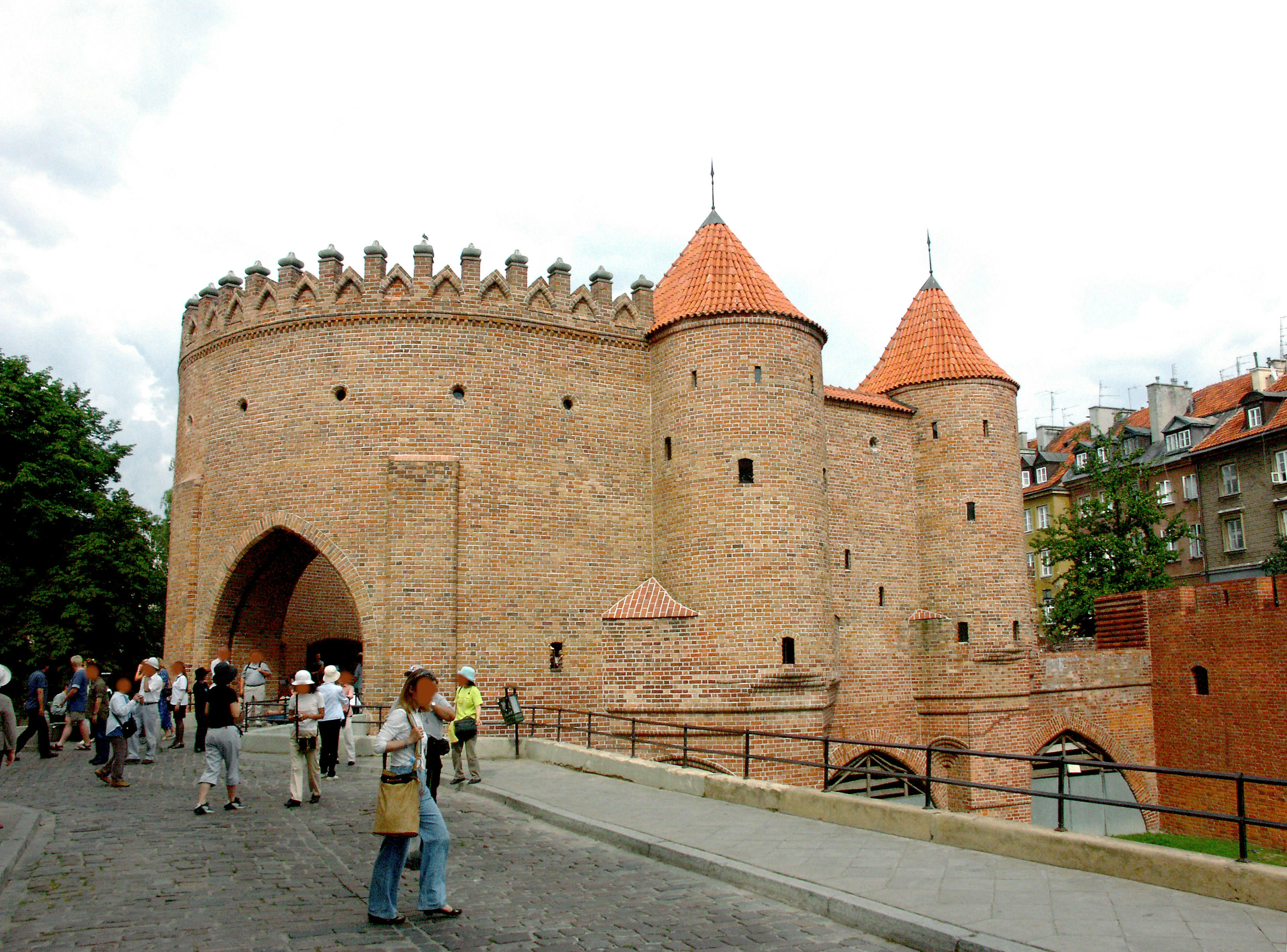 Bâtiment médiéval avec des toits rouges et des tours entouré de touristes