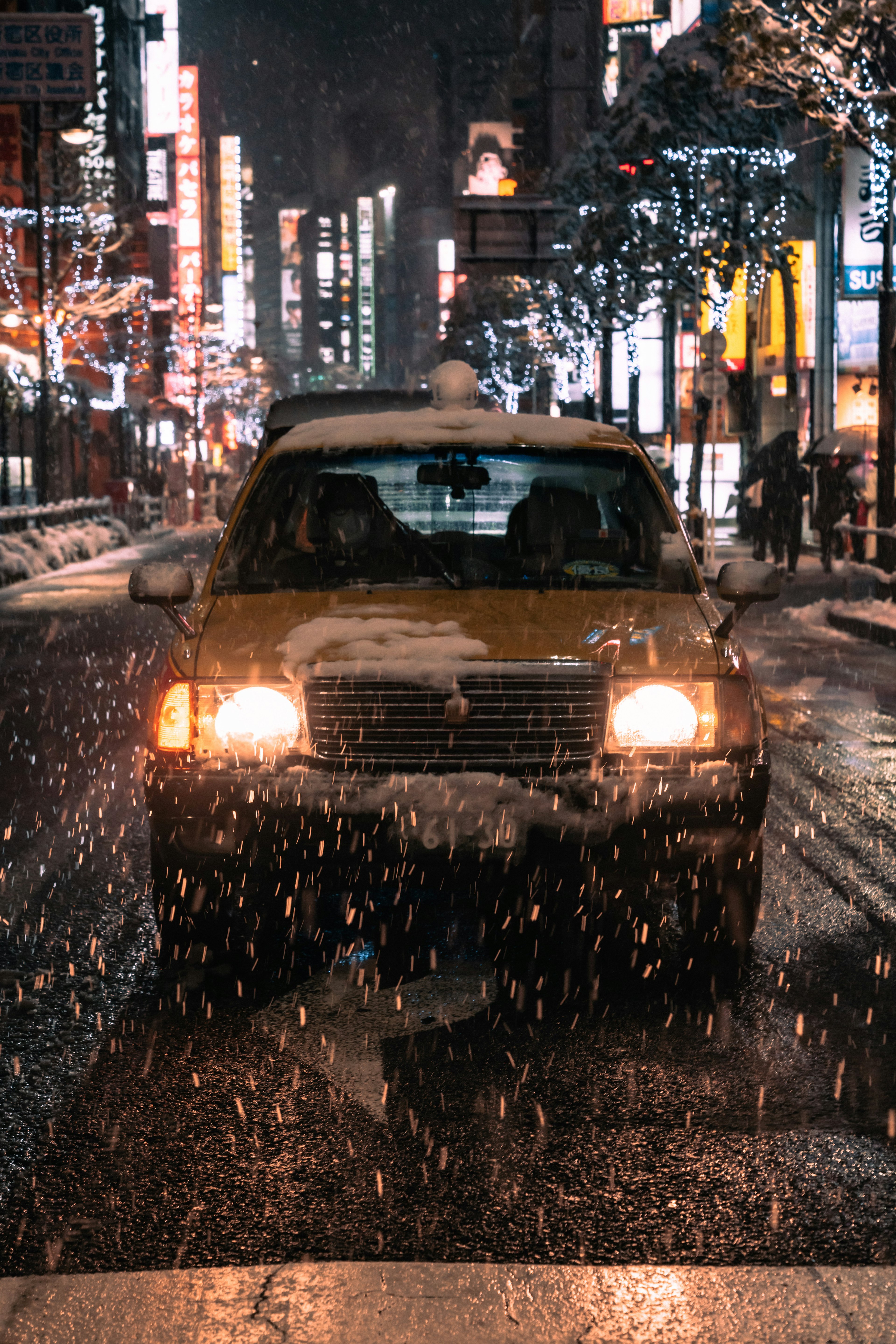 Taxi fährt durch eine verschneite Straße in Tokio bei Nacht