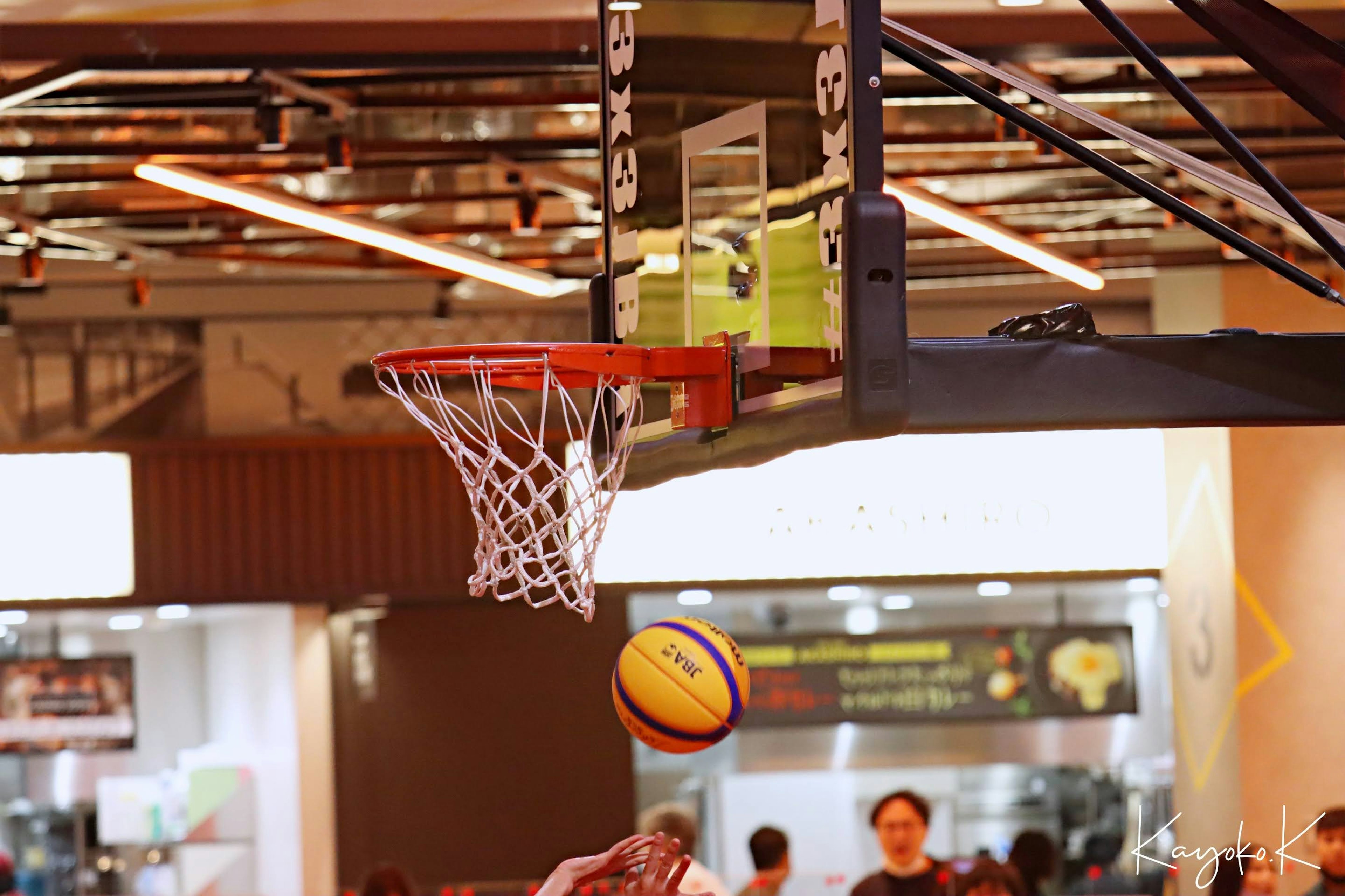 A basketball flying towards the hoop in a sports setting