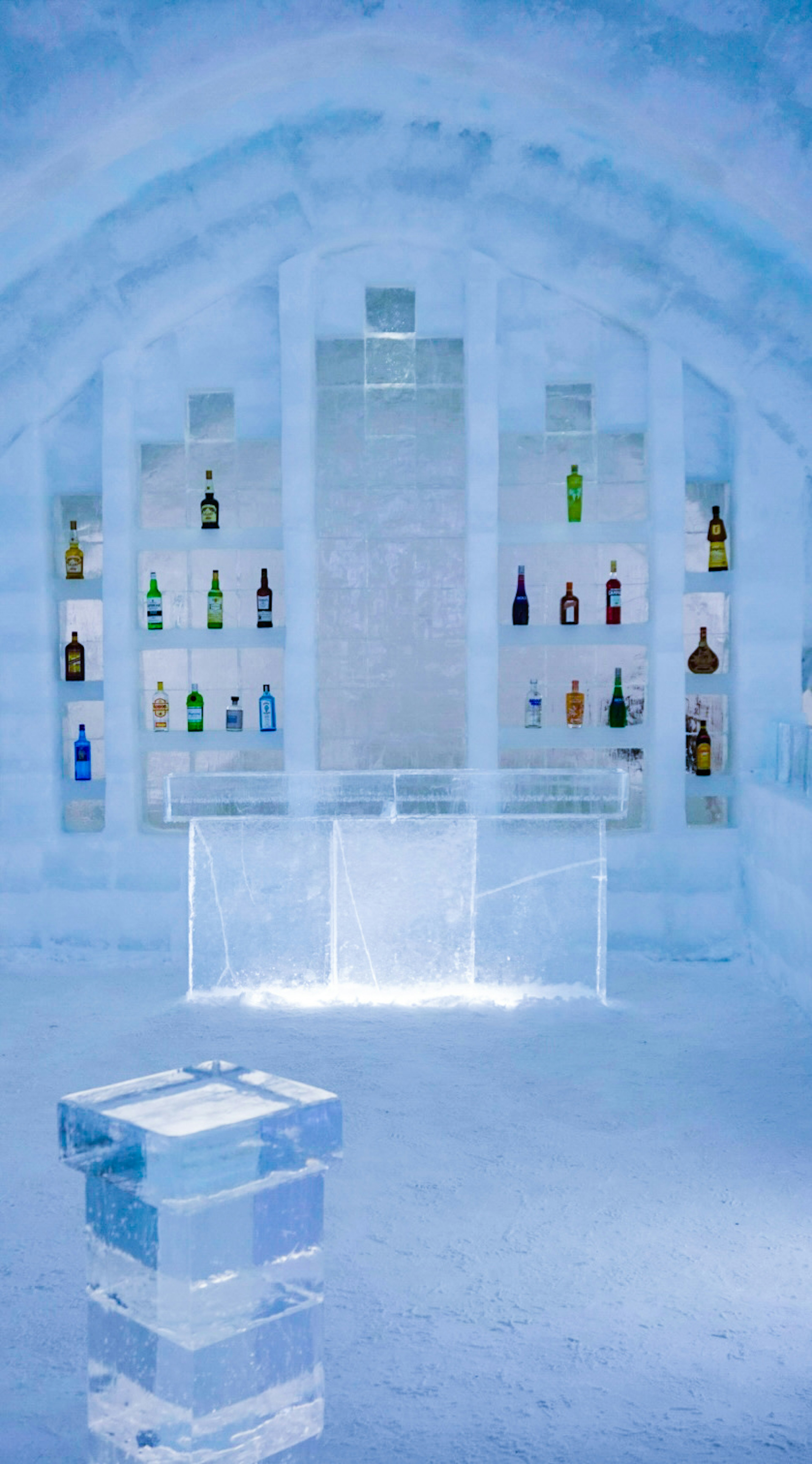 Interior view of an ice bar featuring ice walls and colorful bottles