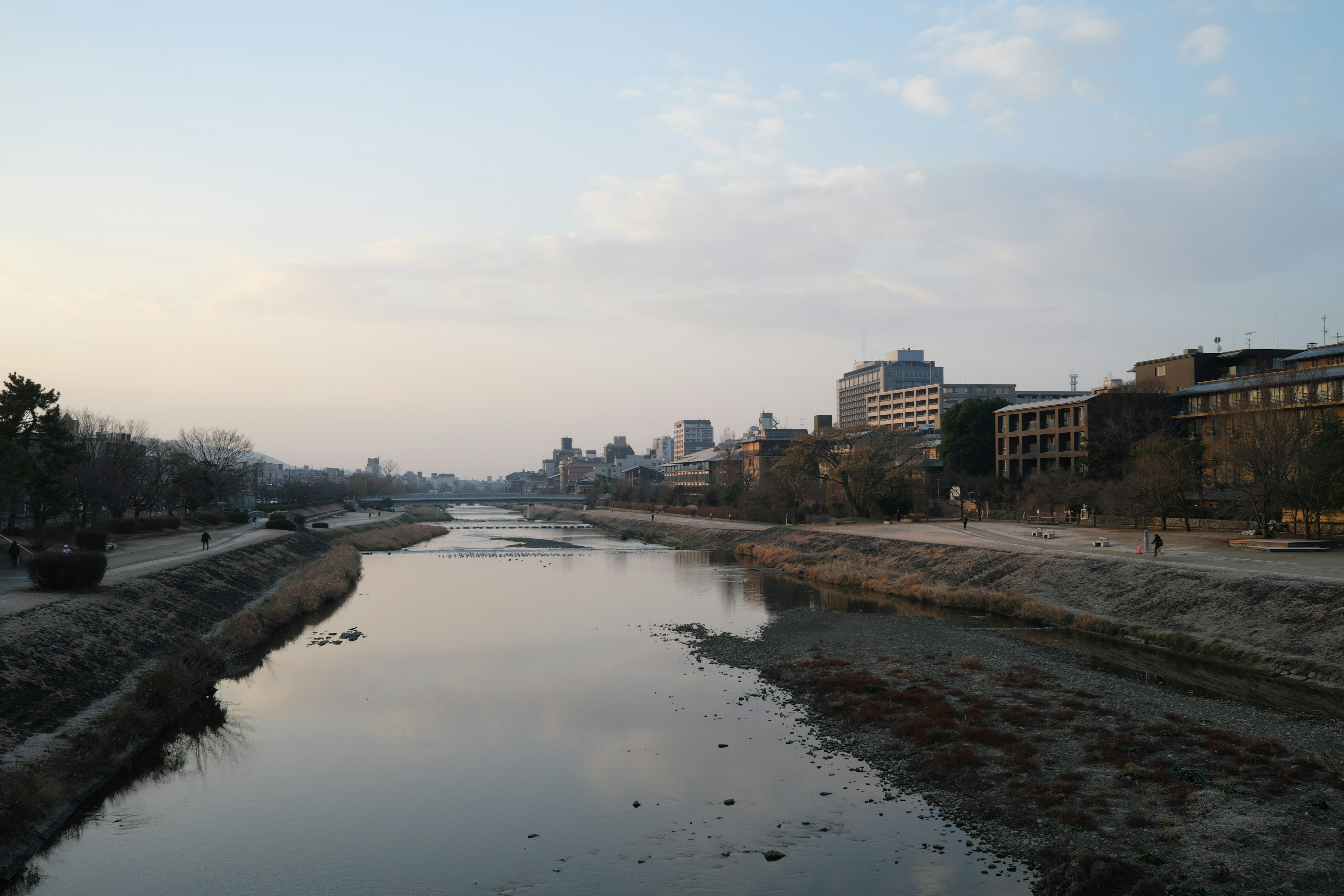 Ruhige Flusslandschaft mit Stadtsilhouette im sanften Abendlicht