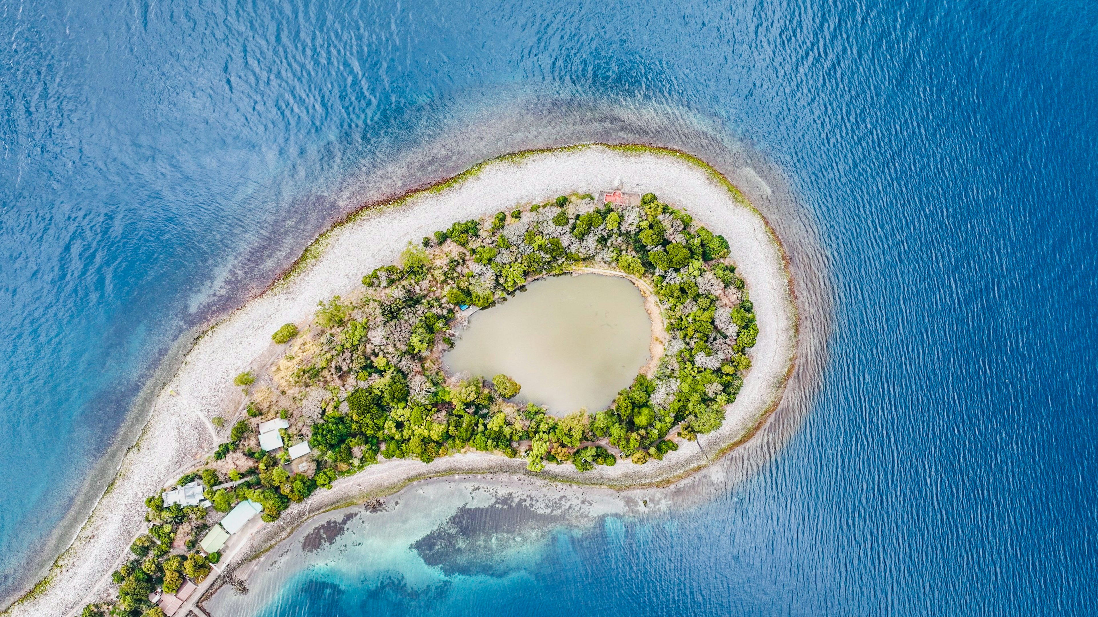 Luftaufnahme einer kleinen Insel umgeben von türkisfarbenem Wasser