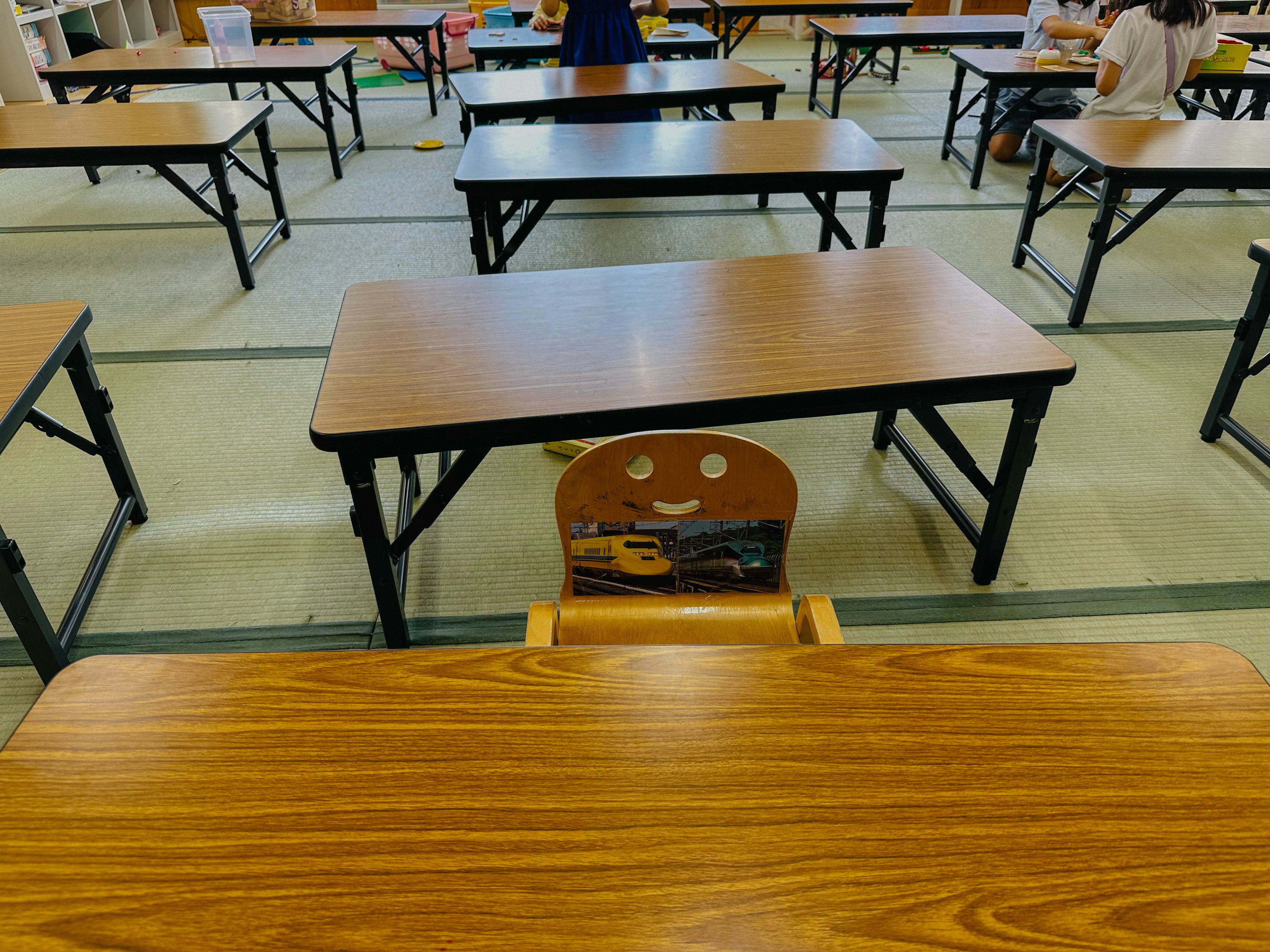 Classroom with rows of desks and chairs featuring a smiling chair