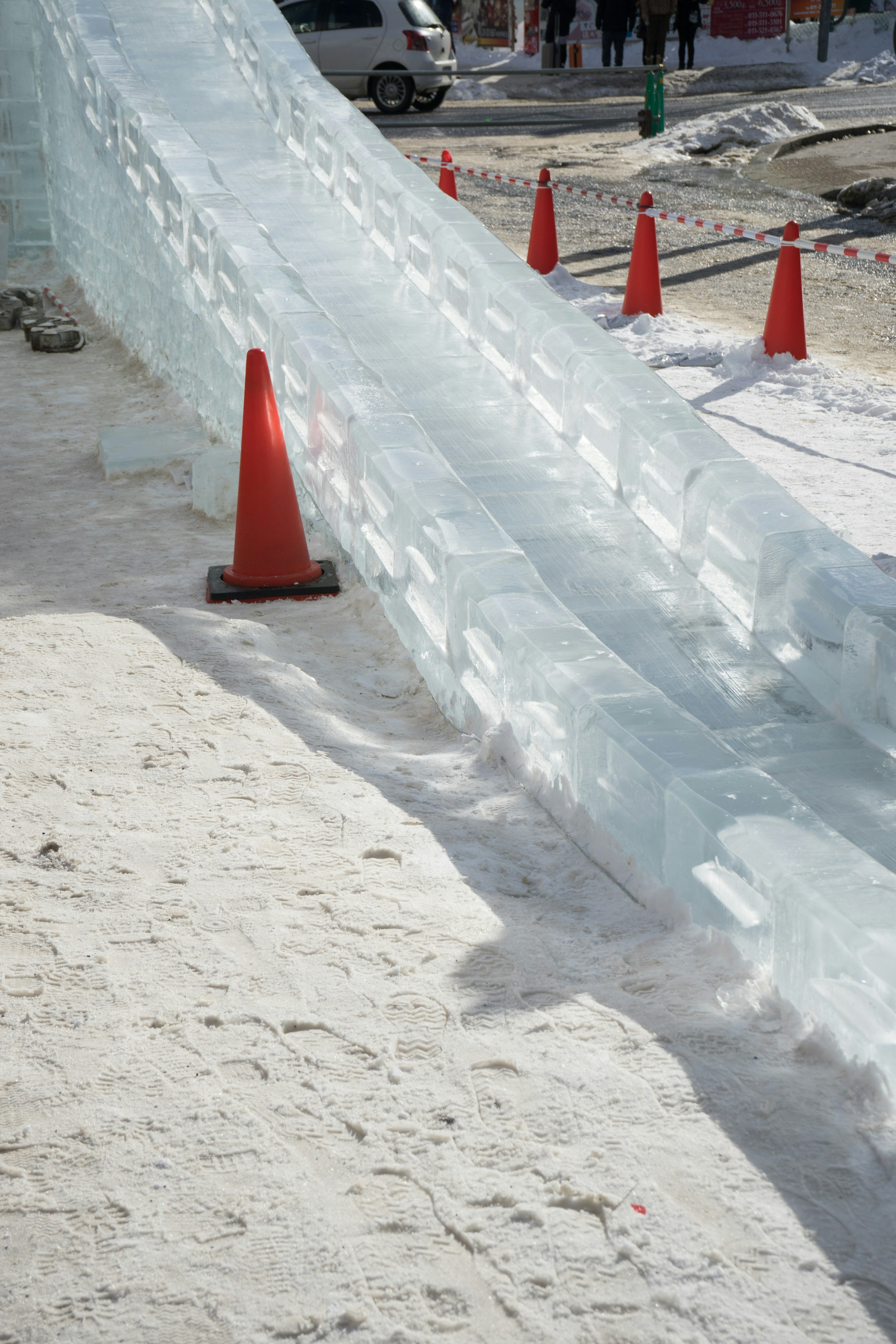 Eisrutsche mit orangen Kegeln in einer Winterlandschaft