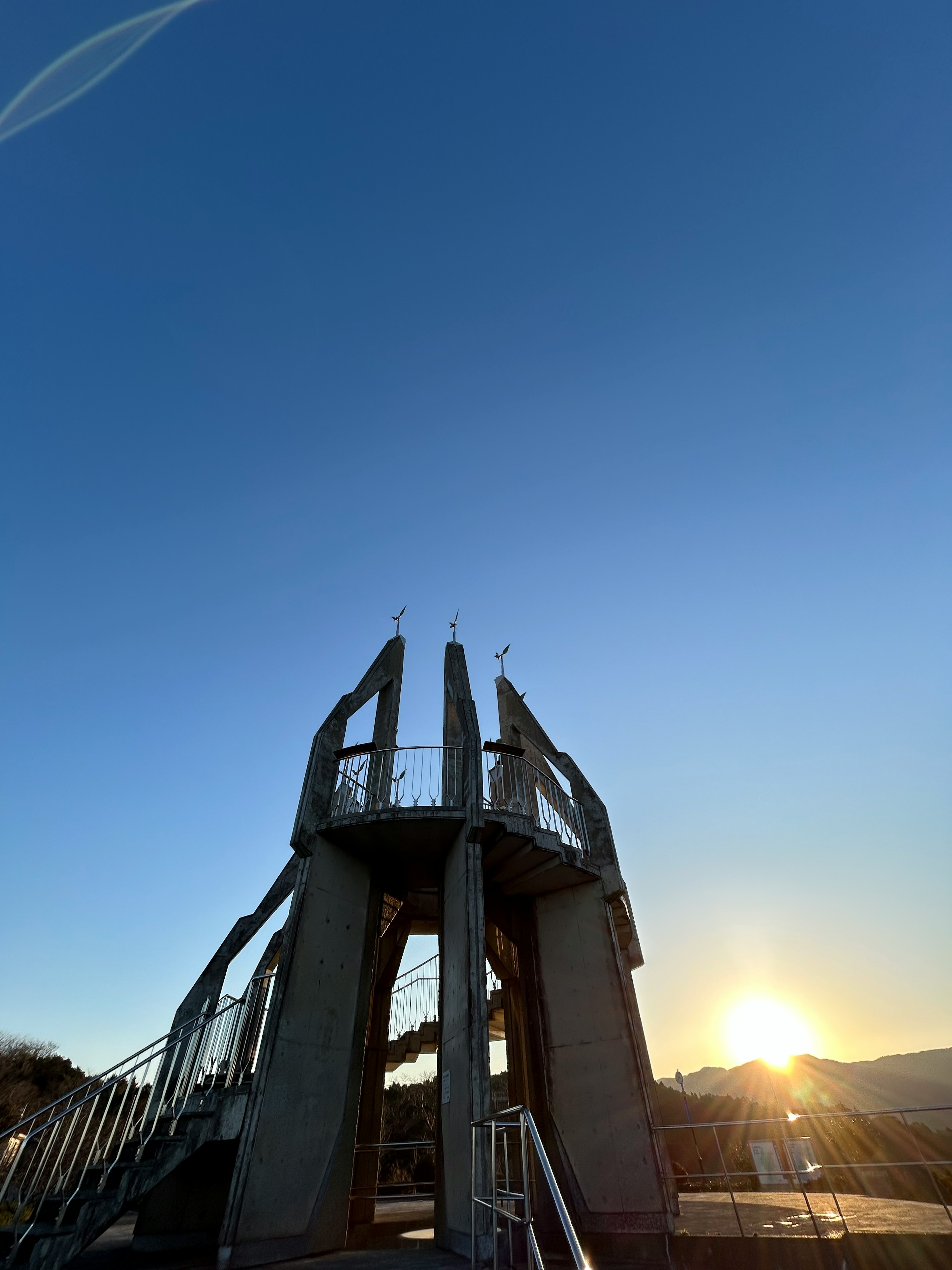 Turmstruktur vor blauem Himmel und Sonnenuntergang