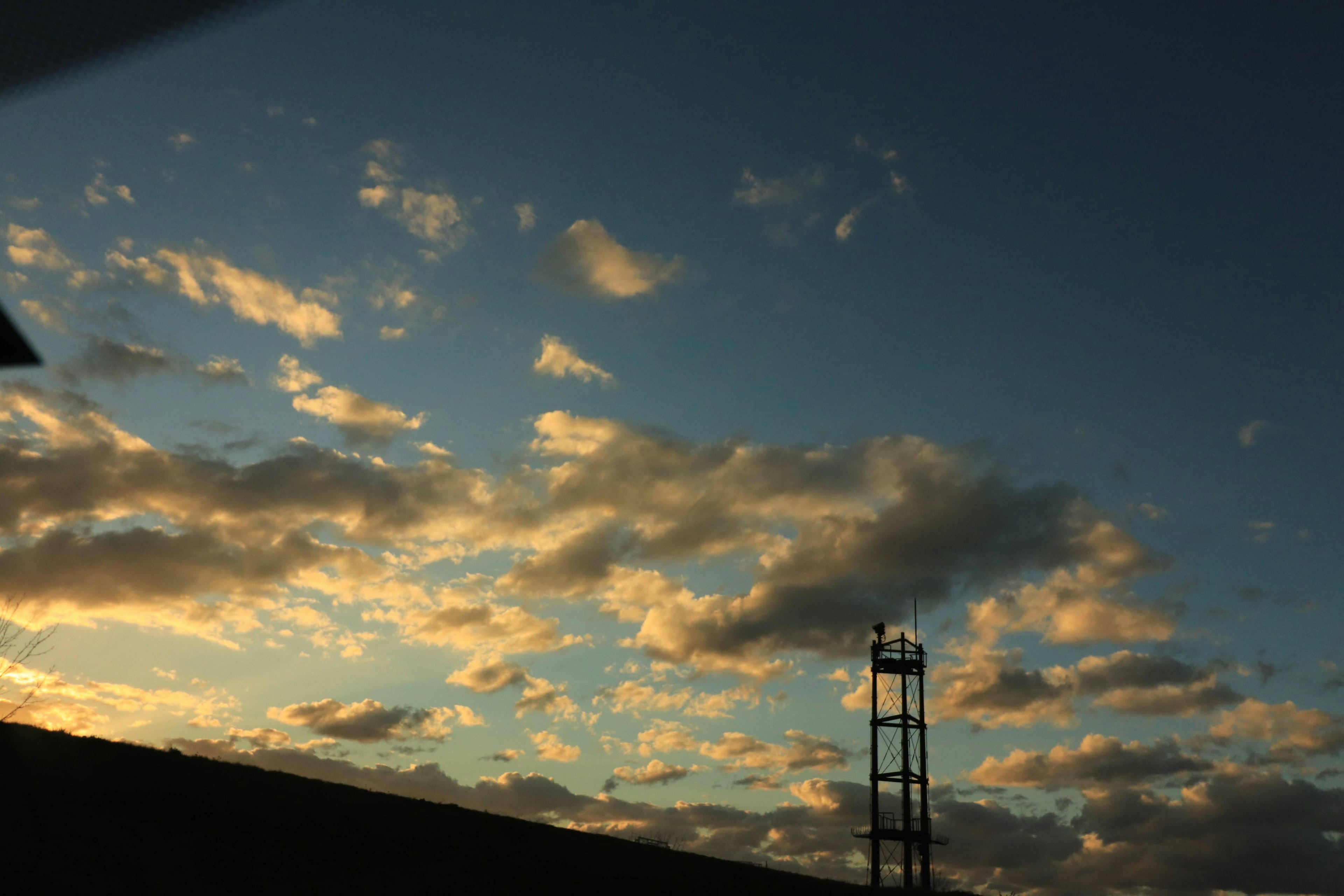 Siluet menara di latar belakang langit senja yang dipenuhi awan