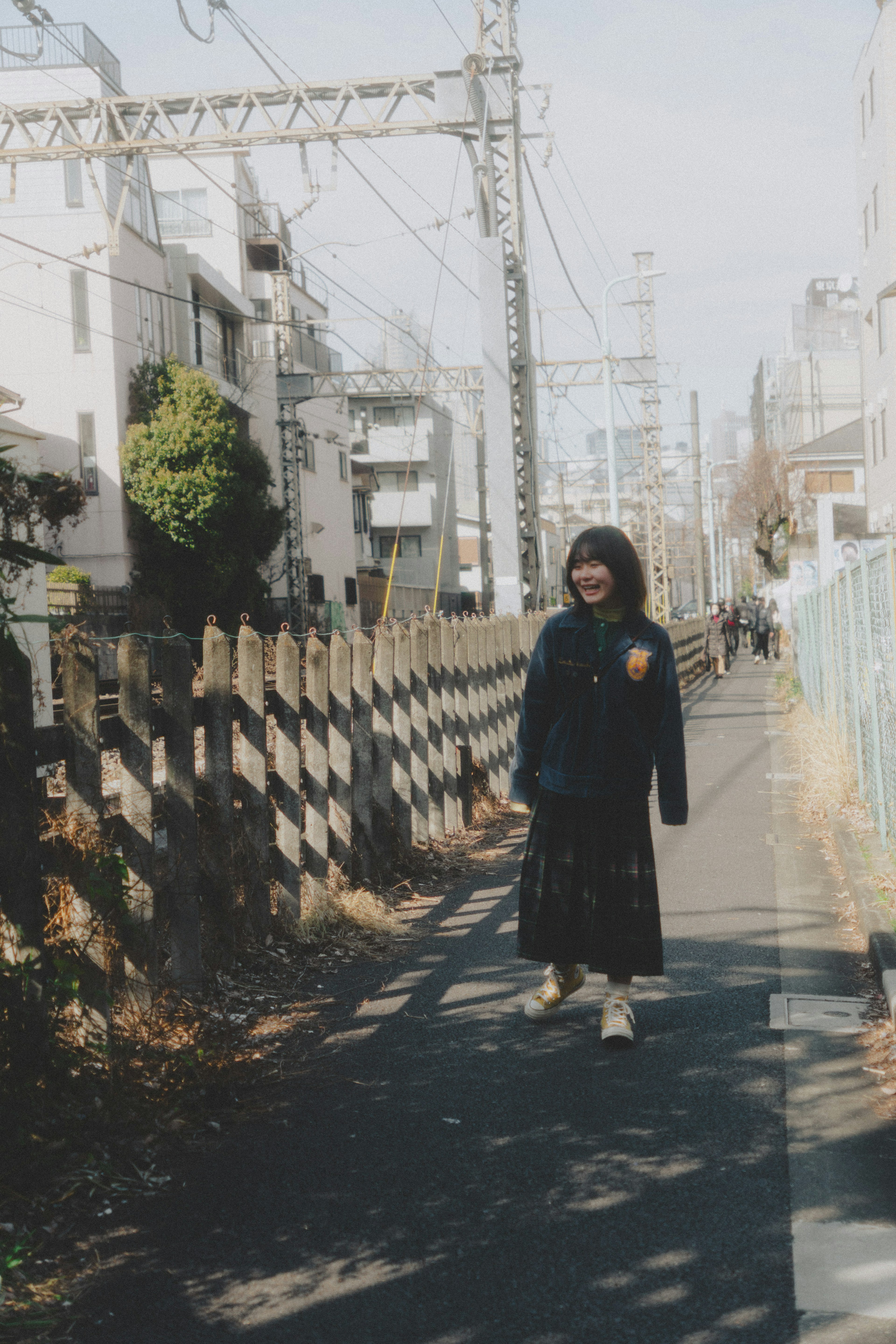 Woman walking along a path with a wooden fence in the background