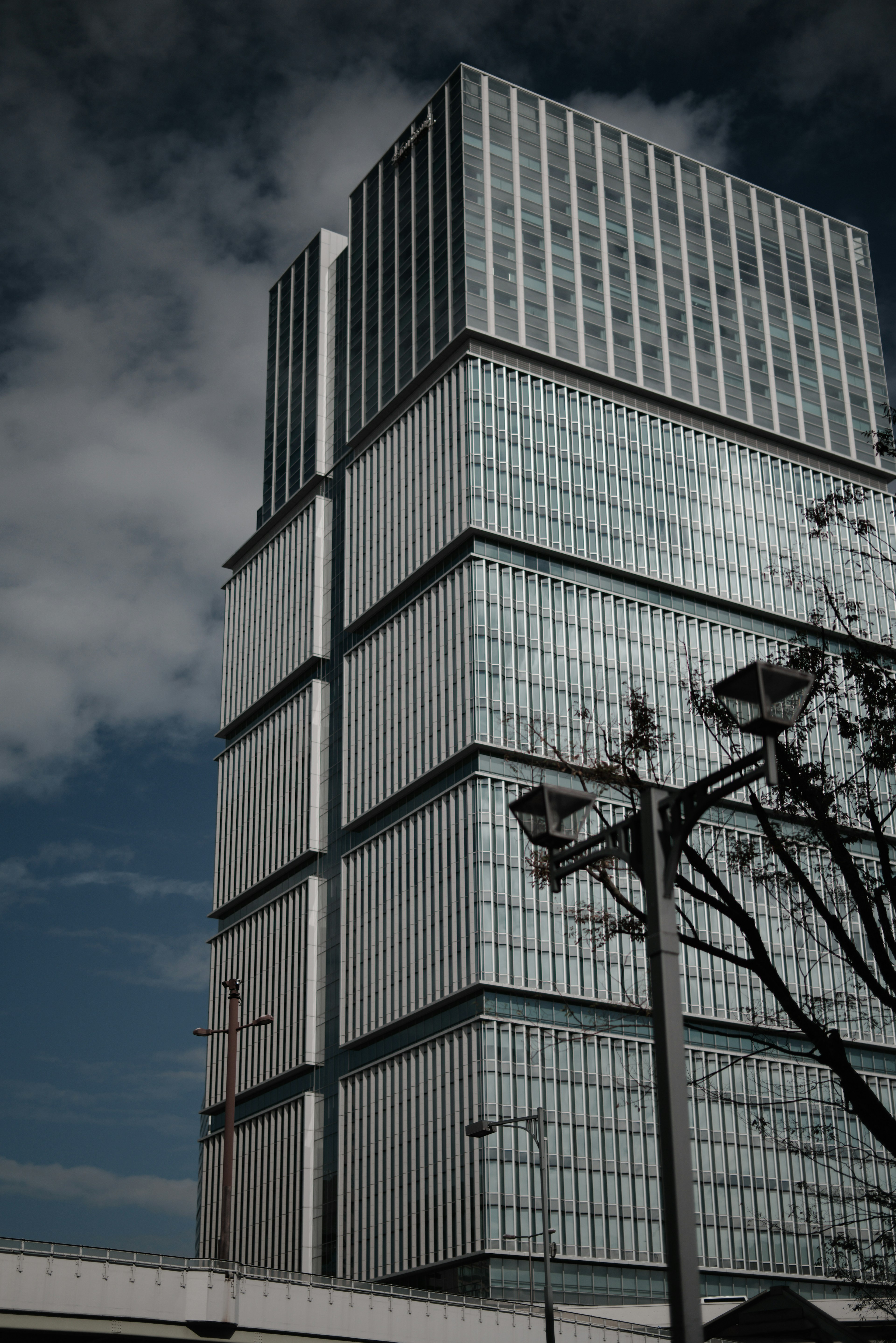 Gedung pencakar langit kaca modern berdiri di bawah langit biru